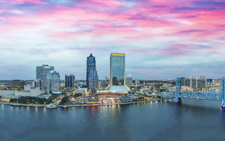 A city skyline with a bridge and a river.