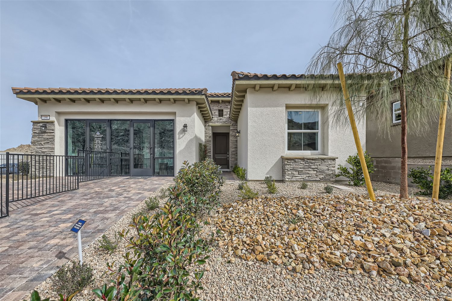 A house with a fence and a gravel driveway.