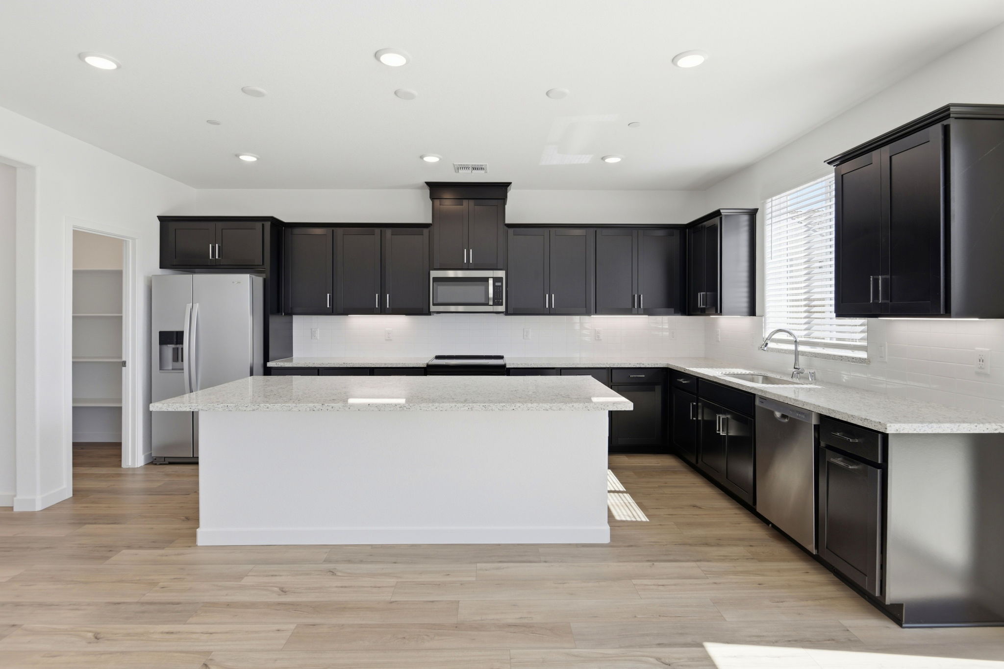 A kitchen with black cabinets.