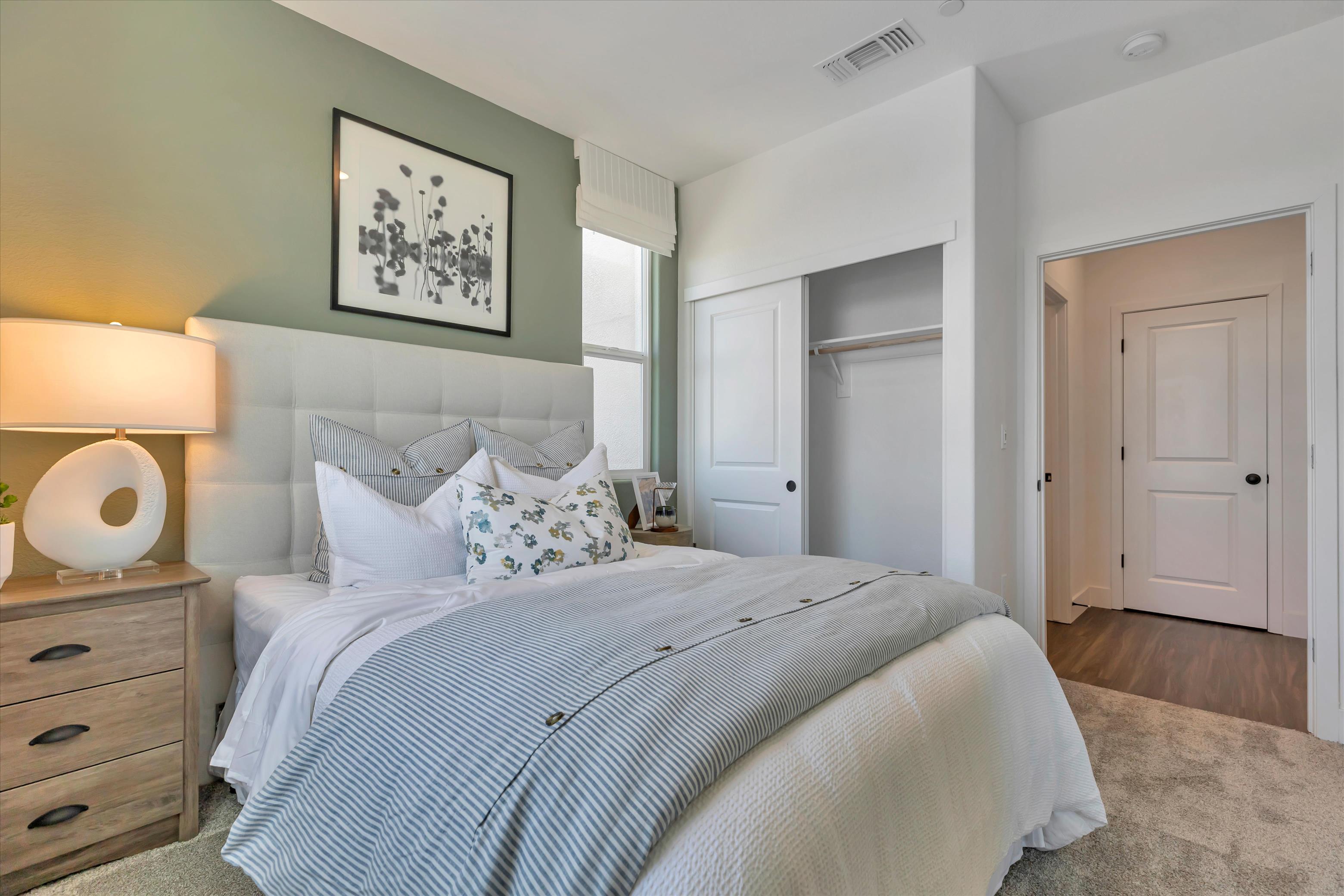 A bedroom with a bed and a lamp.