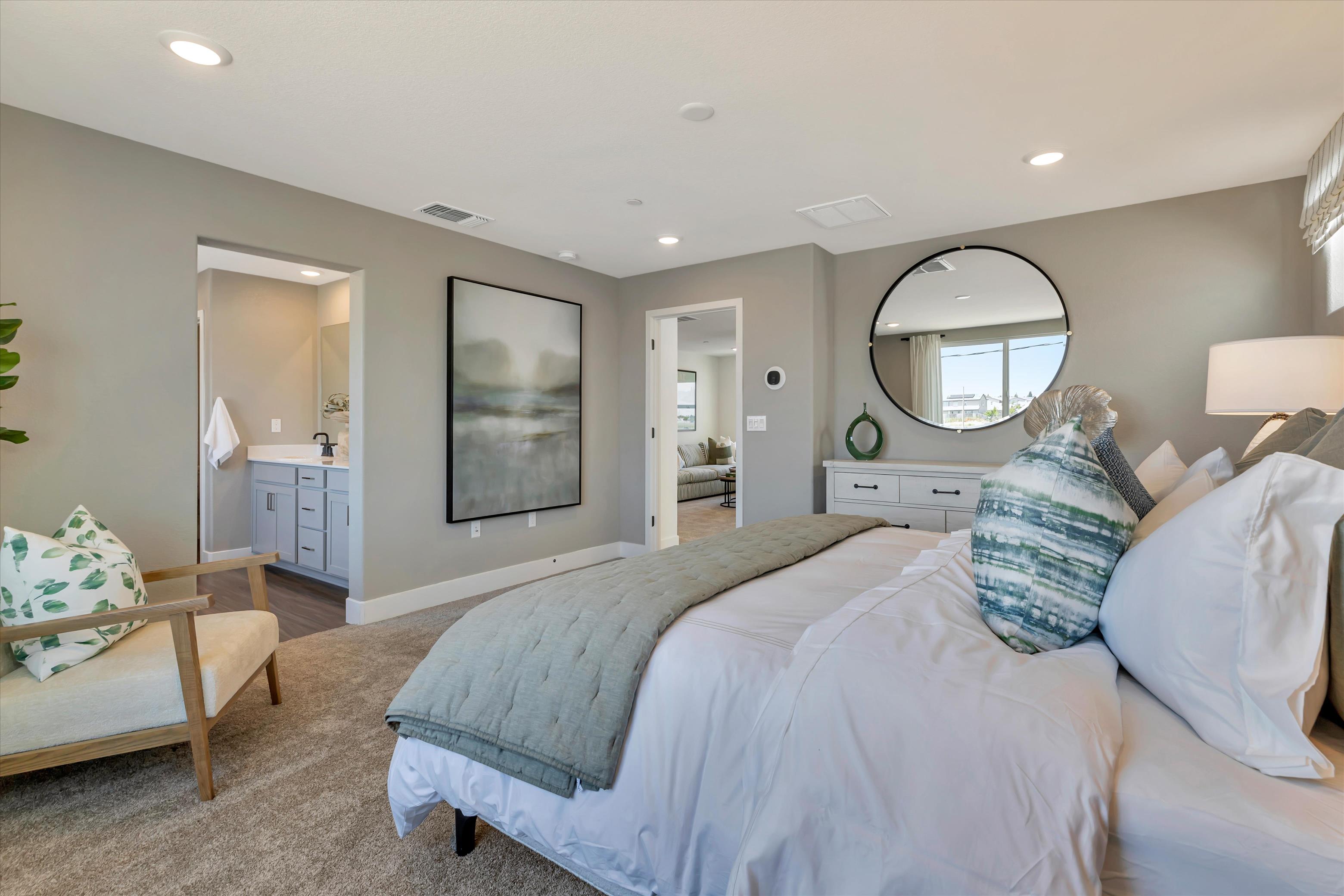 A bedroom with a bed and a mirror.