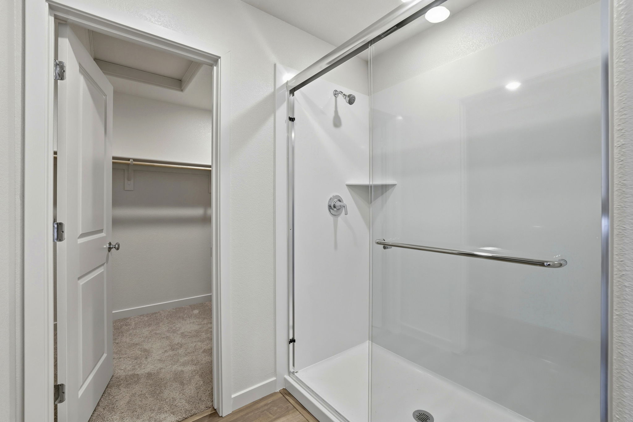A bathroom with a shower unit and a toilet.