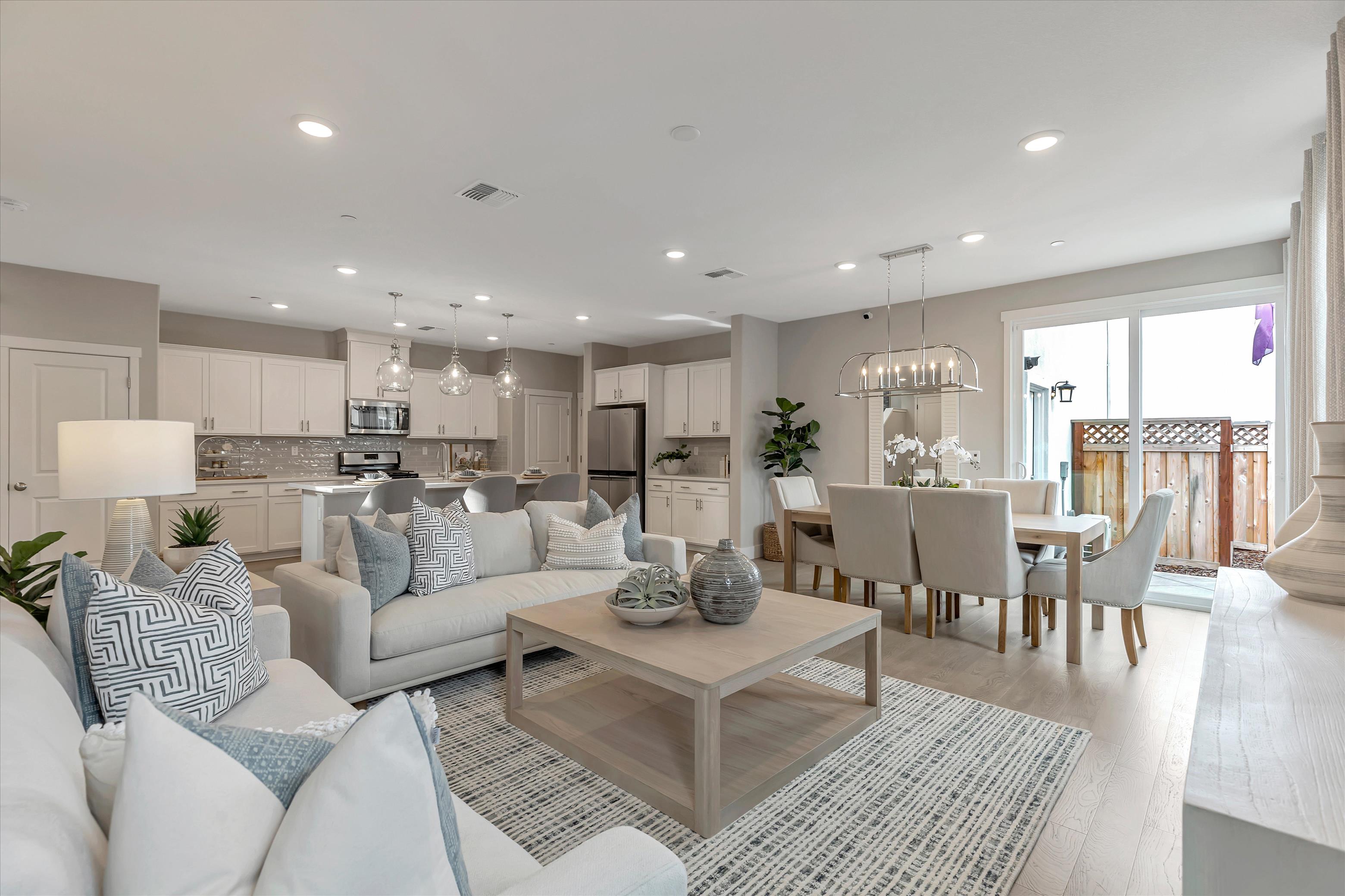 A large living room with a large chandelier and a dining table.