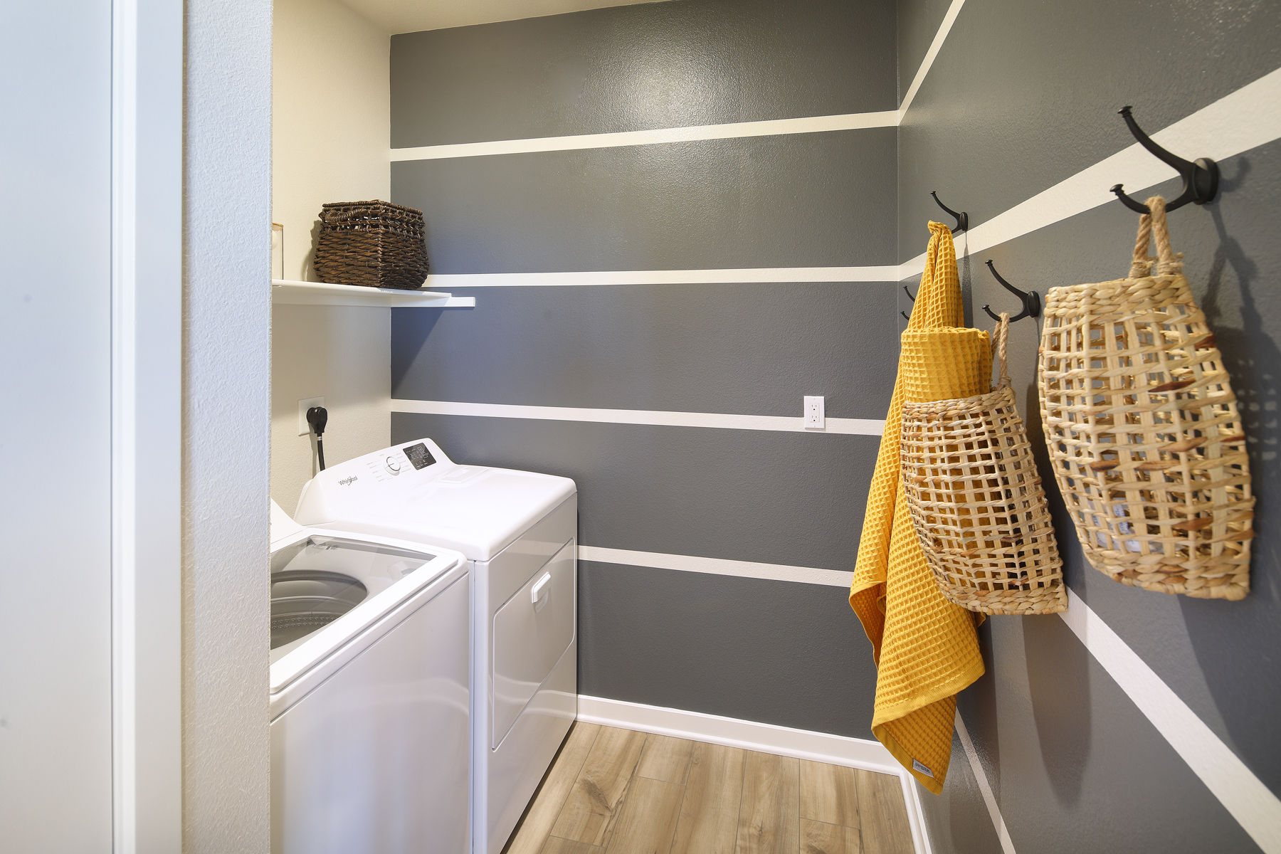 A bathroom with a sink and a shelf with baskets.