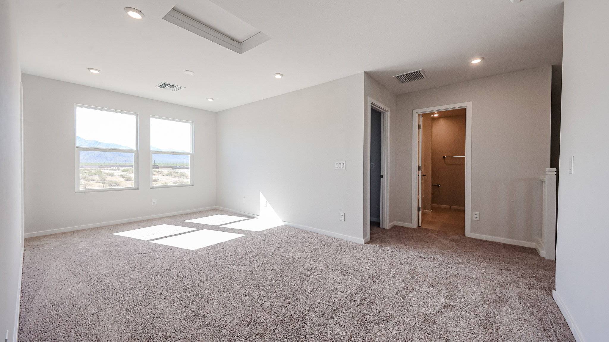 A room with a carpet and windows.