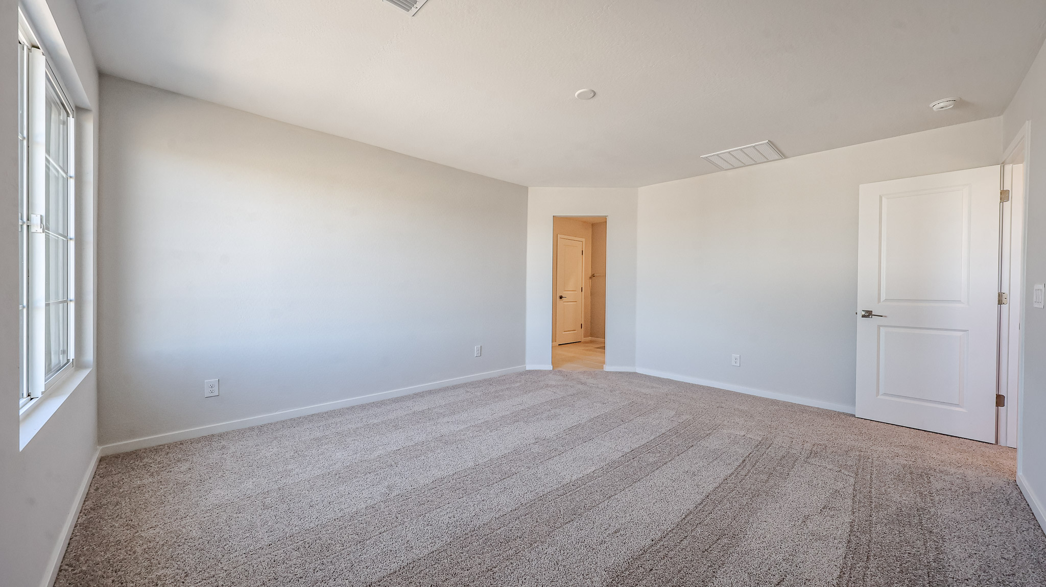 A room with a carpet and a door.