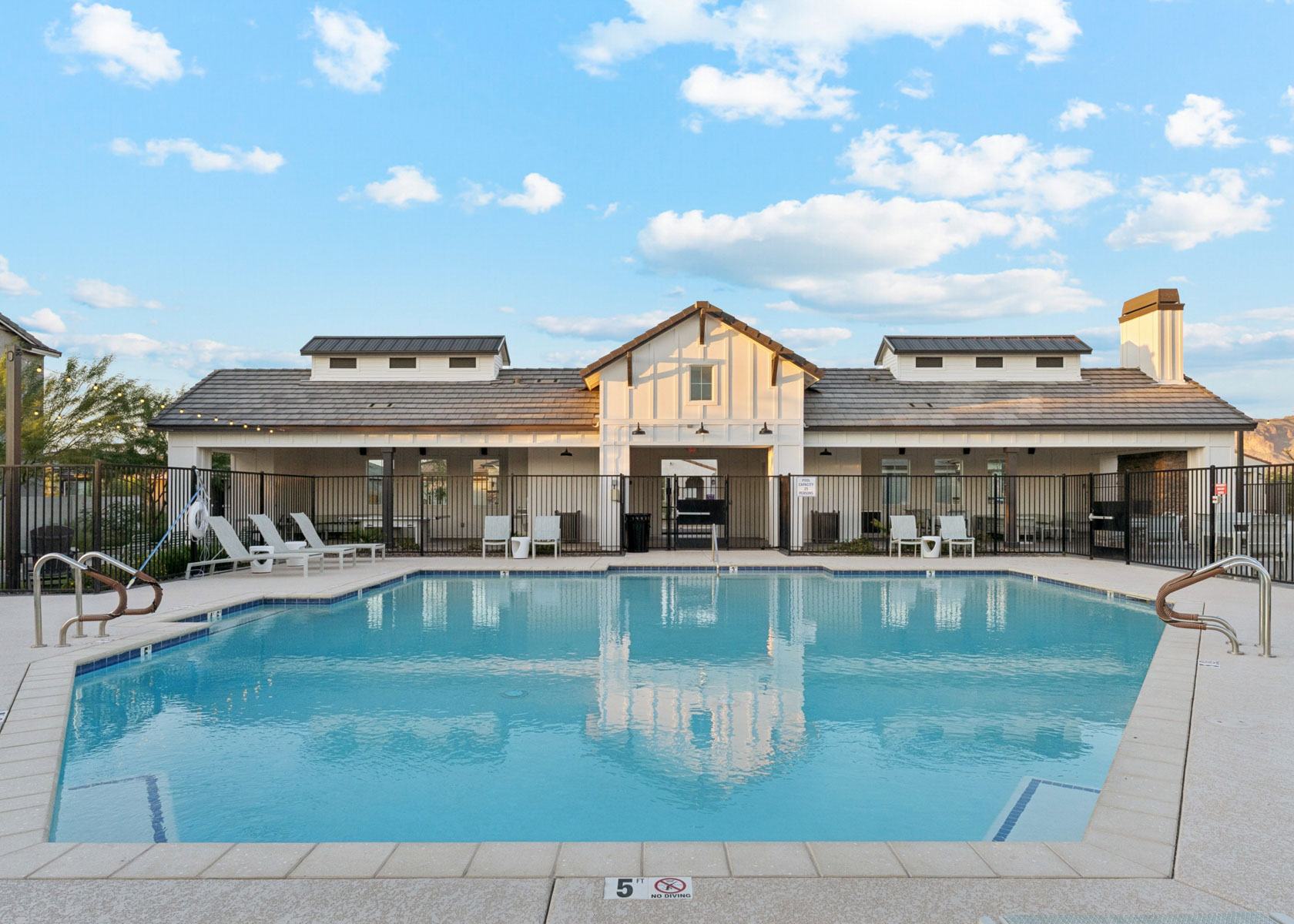 A swimming pool in front of a house.