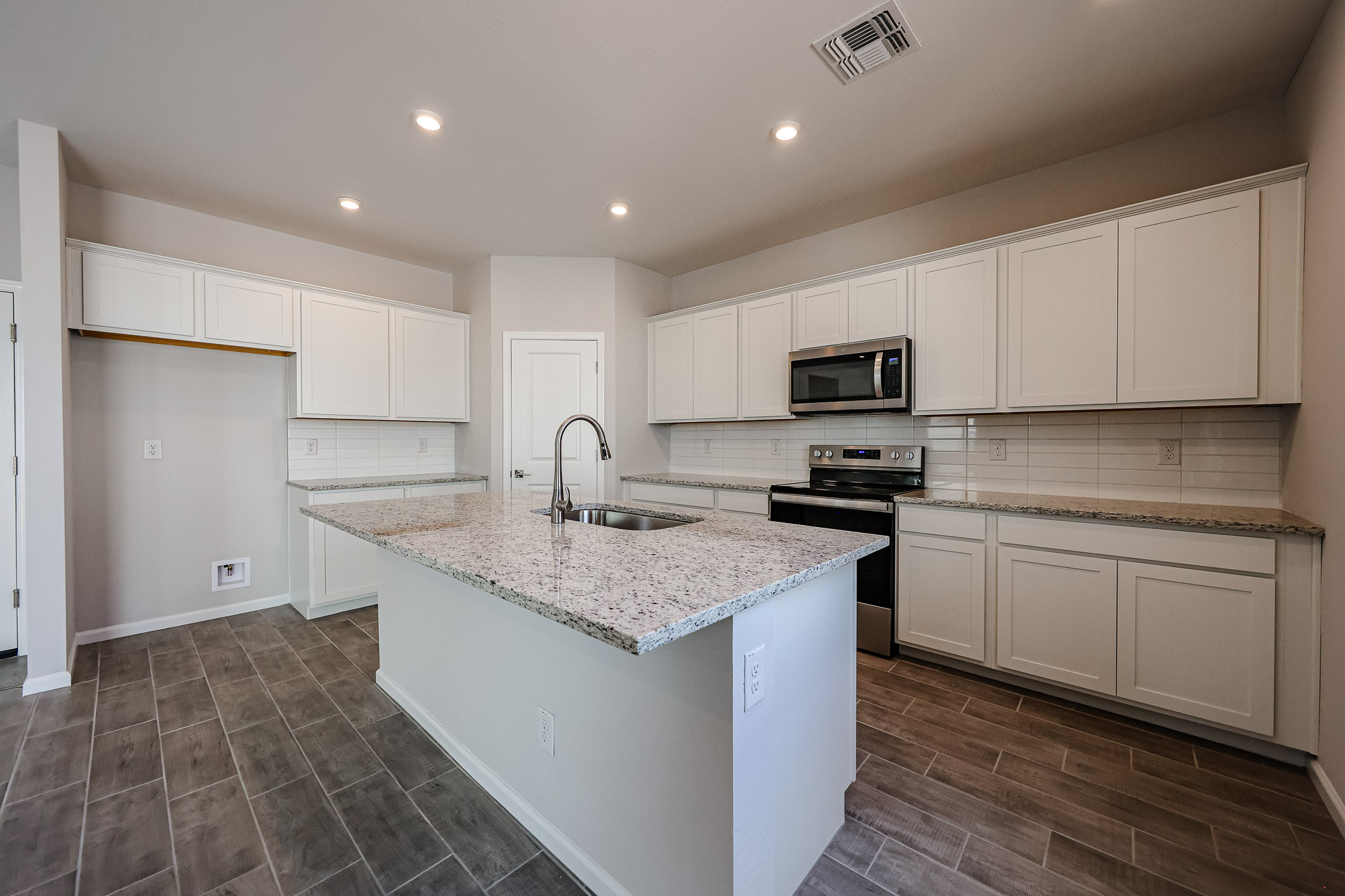 A kitchen with white cabinets.