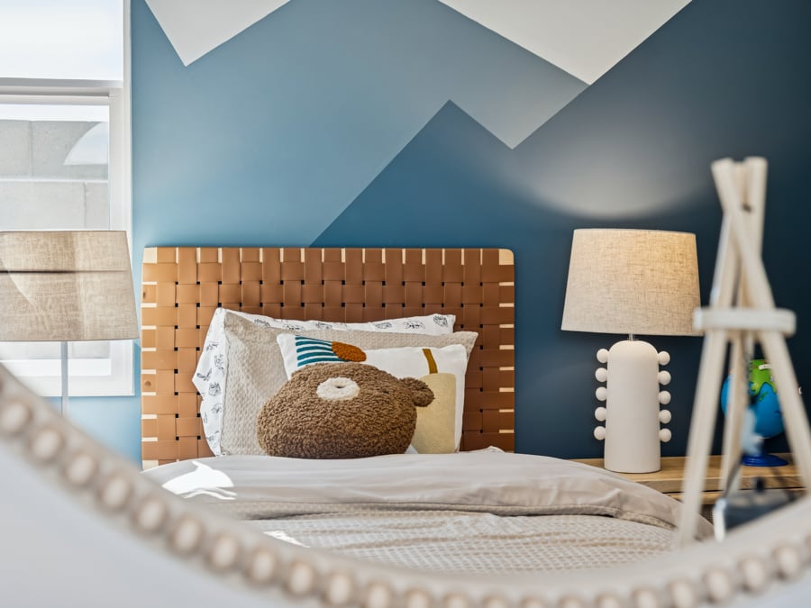 A bed with a lamp and a pillow.