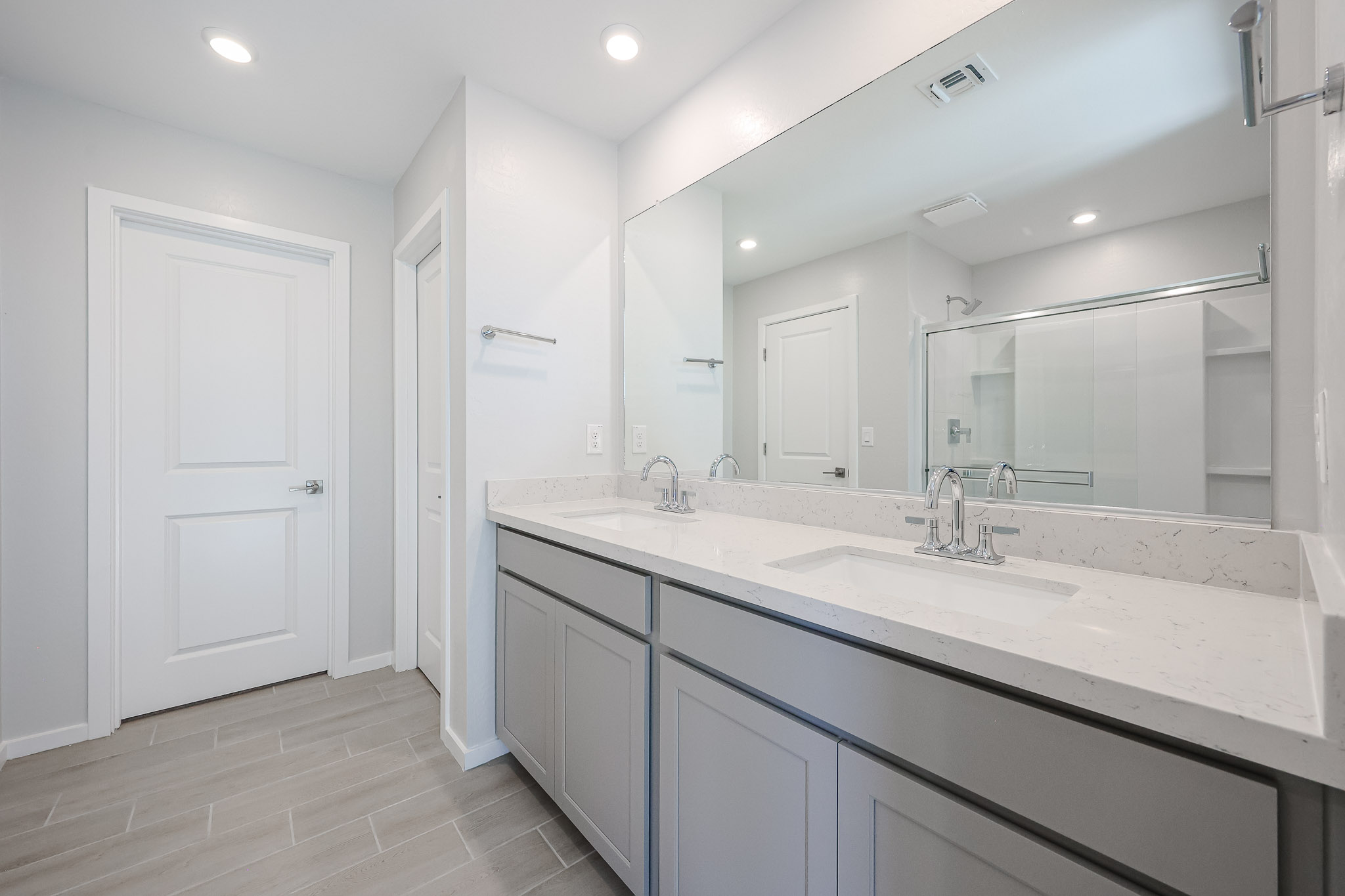 A bathroom with a large mirror.