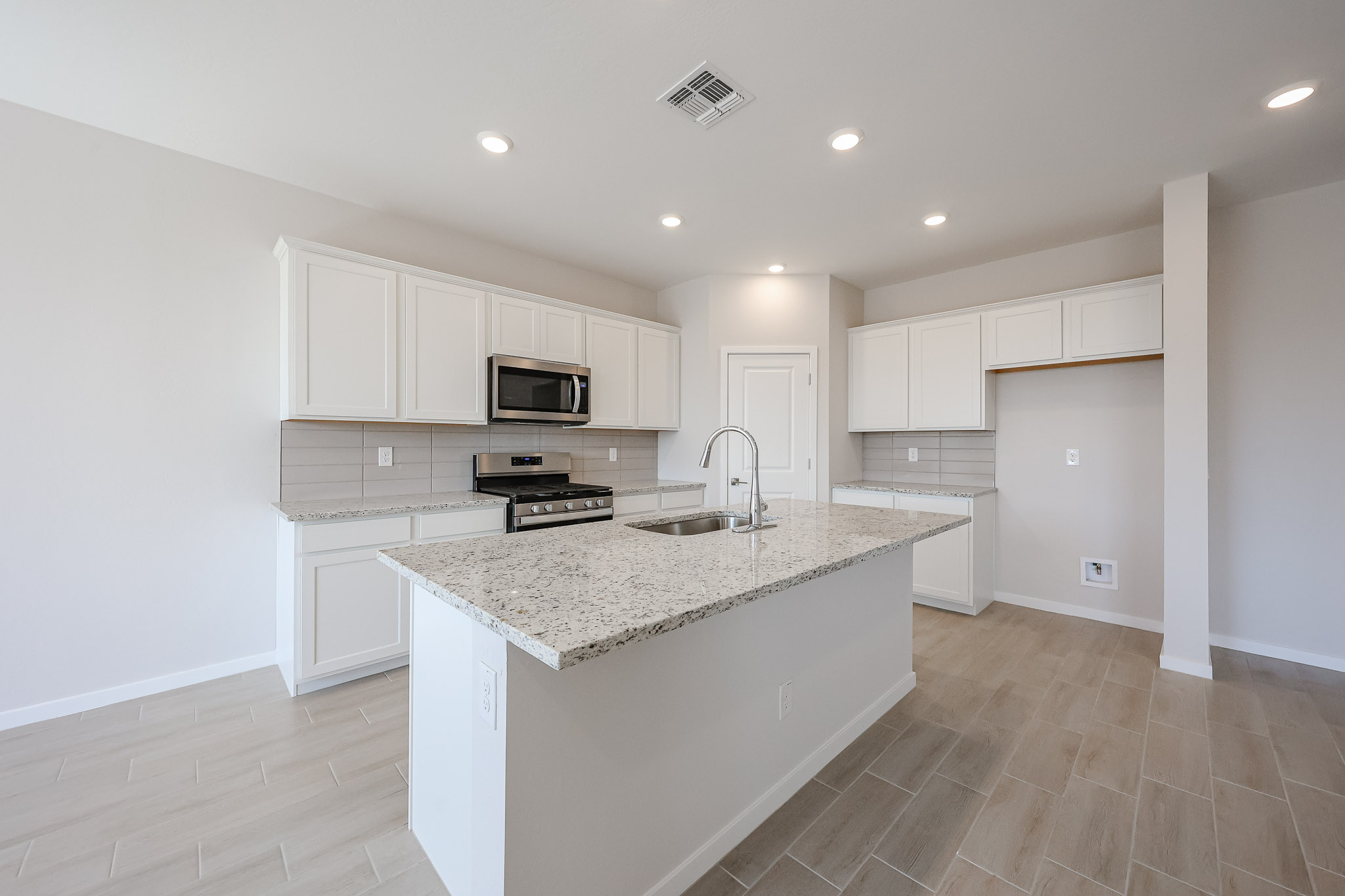 A kitchen with white cabinets.