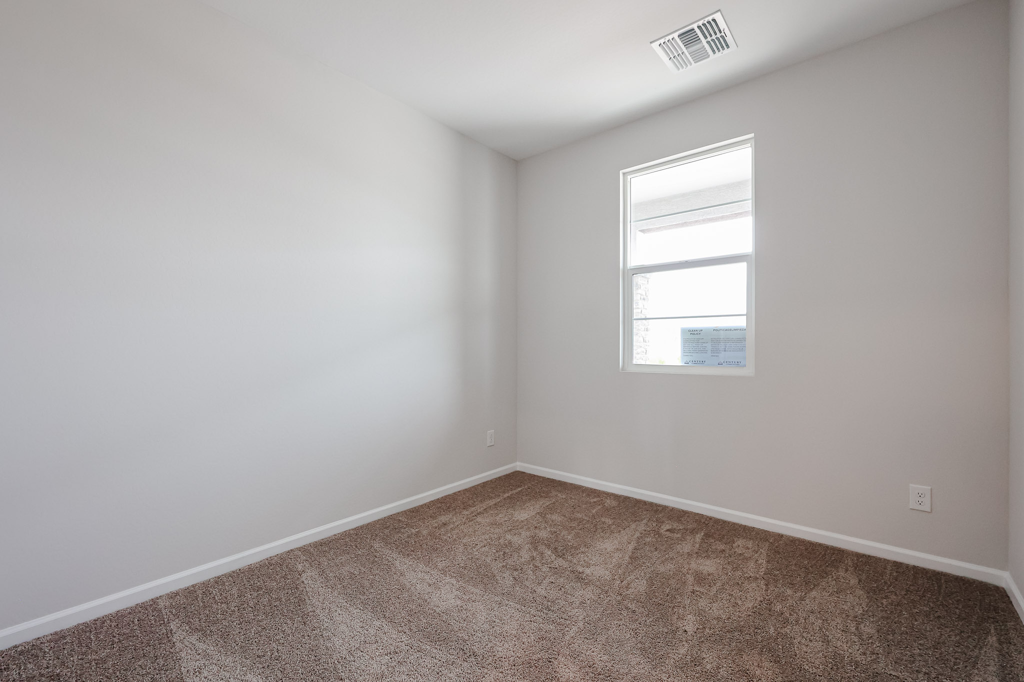 A room with a window and carpet.