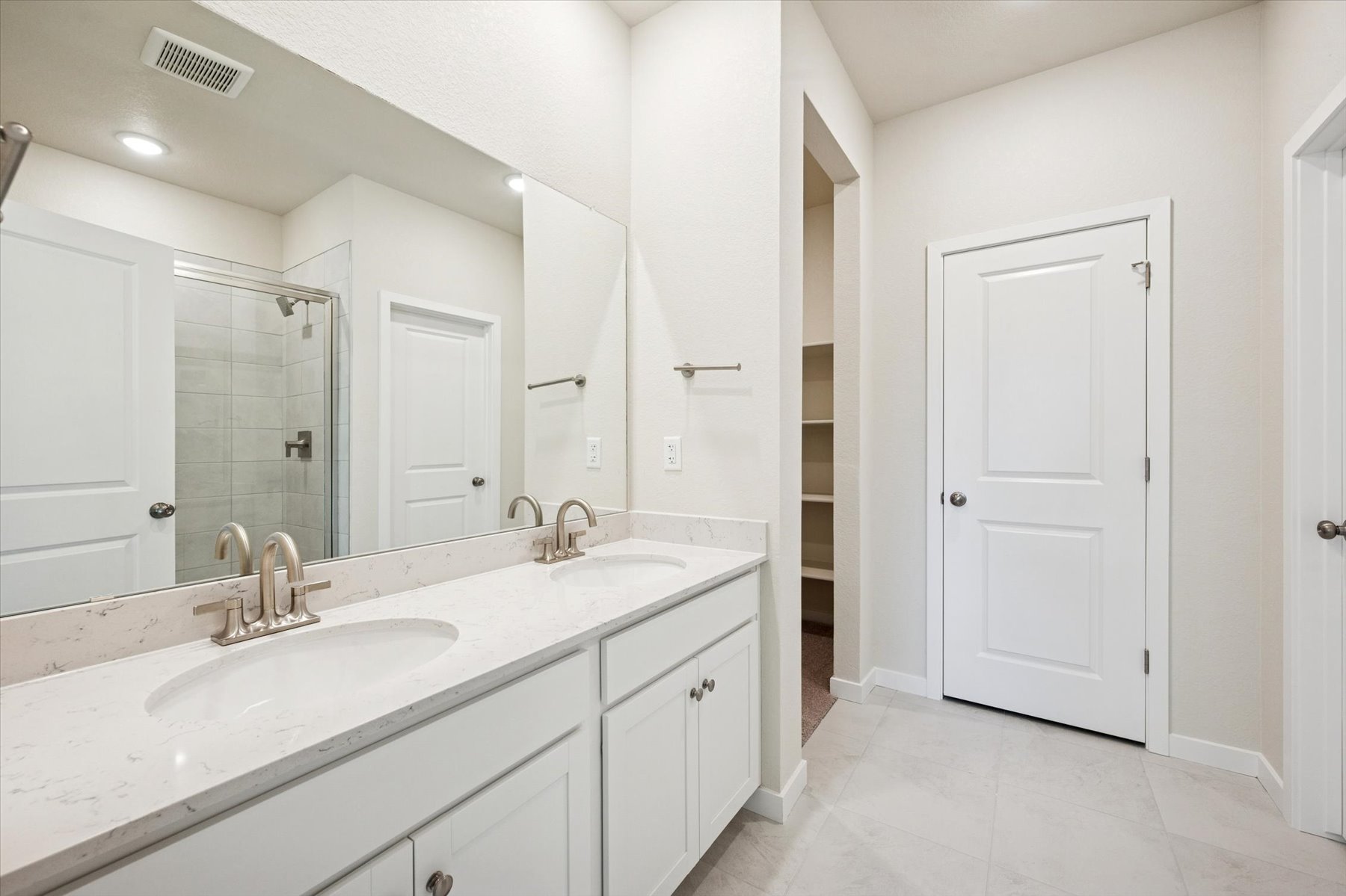 A bathroom with white cabinets.