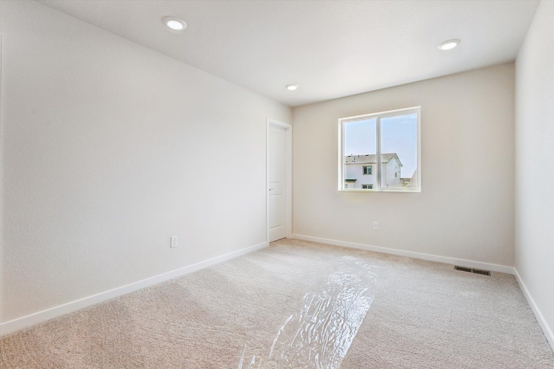 A room with a carpet and a window.