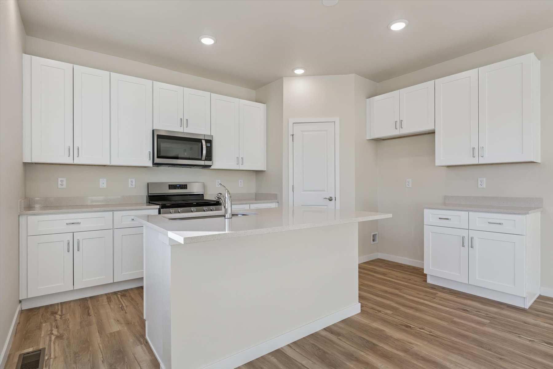 A kitchen with white cabinets.