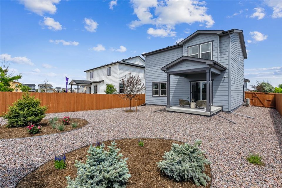 A house with a fence and a dirt yard.