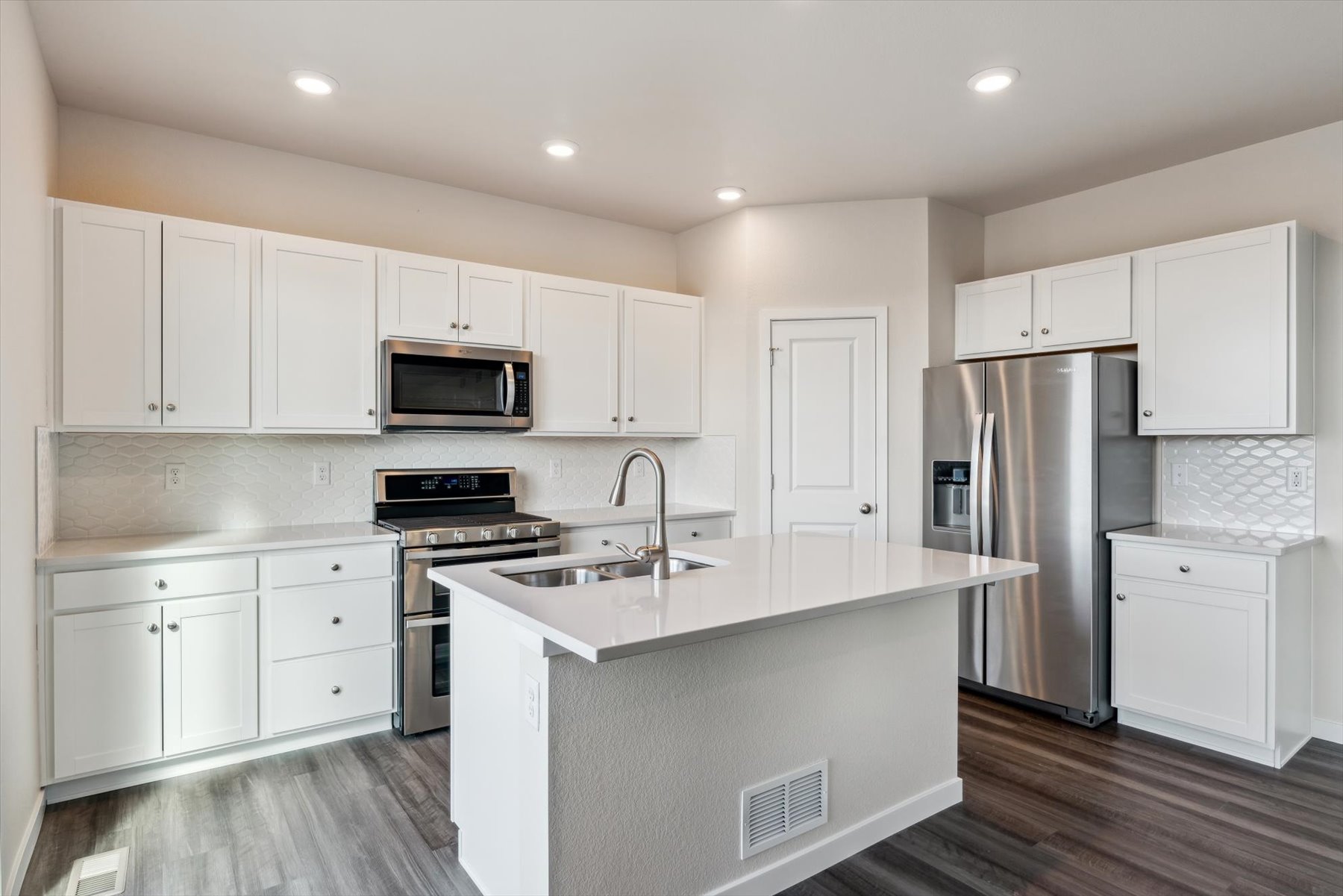 A kitchen with white cabinets.