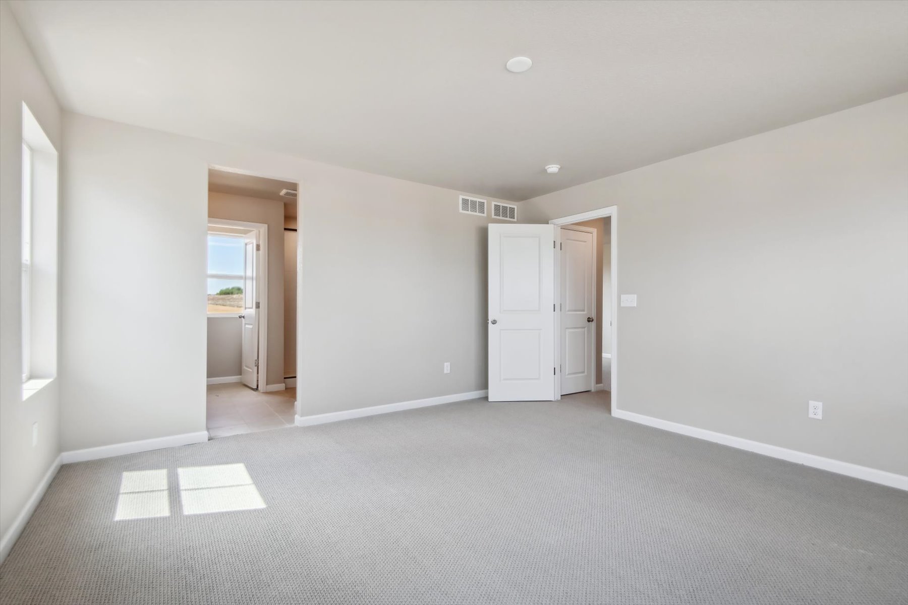 A long hallway with white doors.