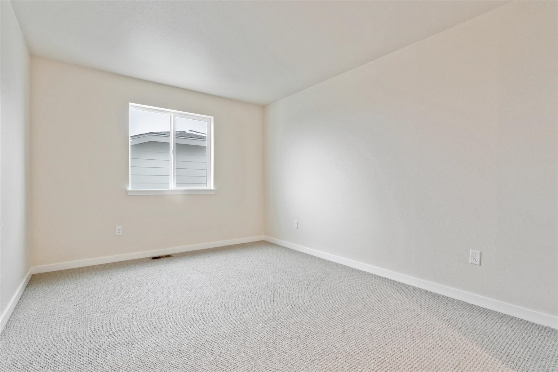 A room with a window and a carpet.