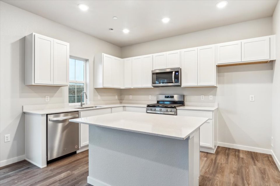 A kitchen with white cabinets.