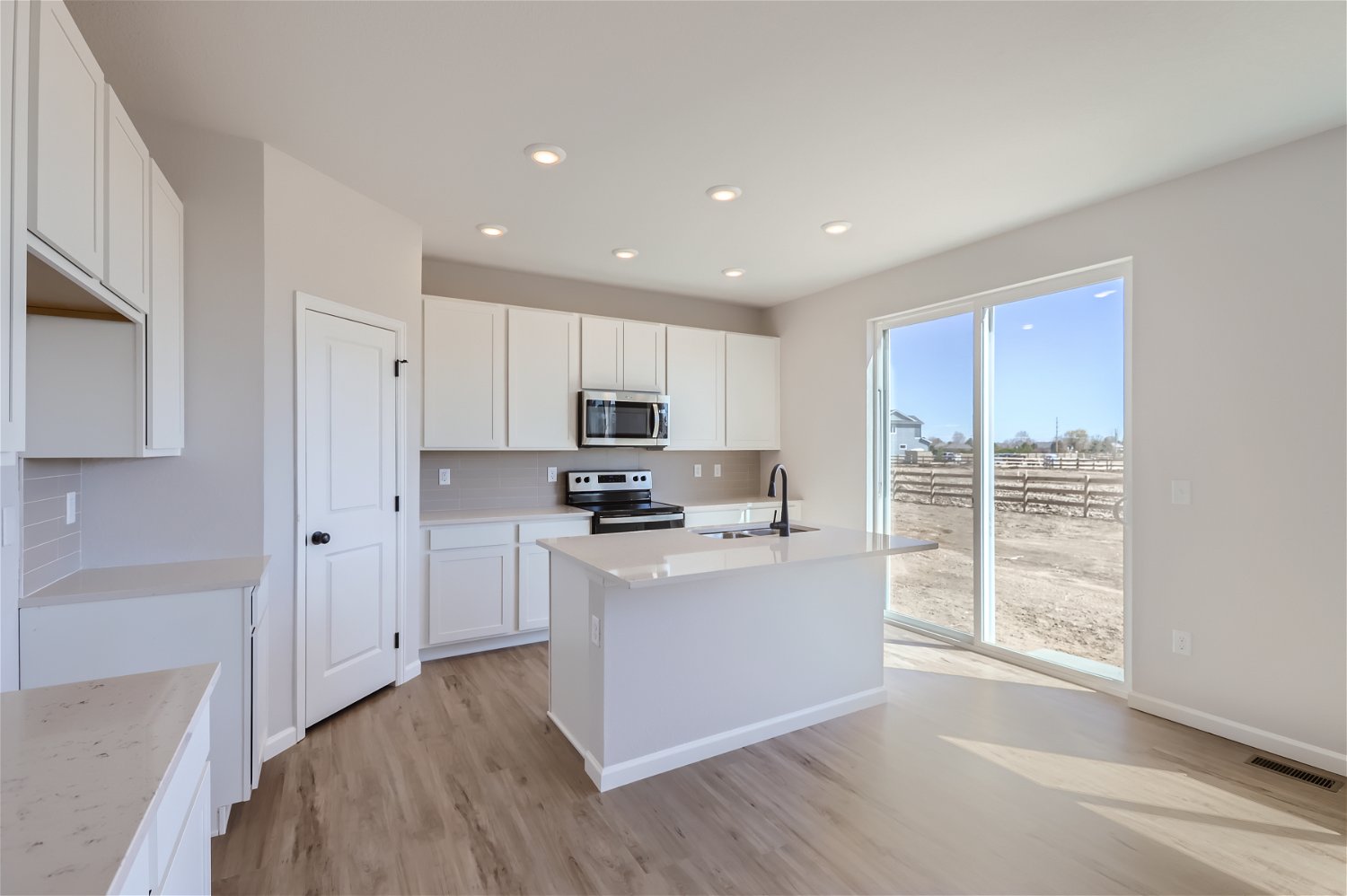 A kitchen with white cabinets.