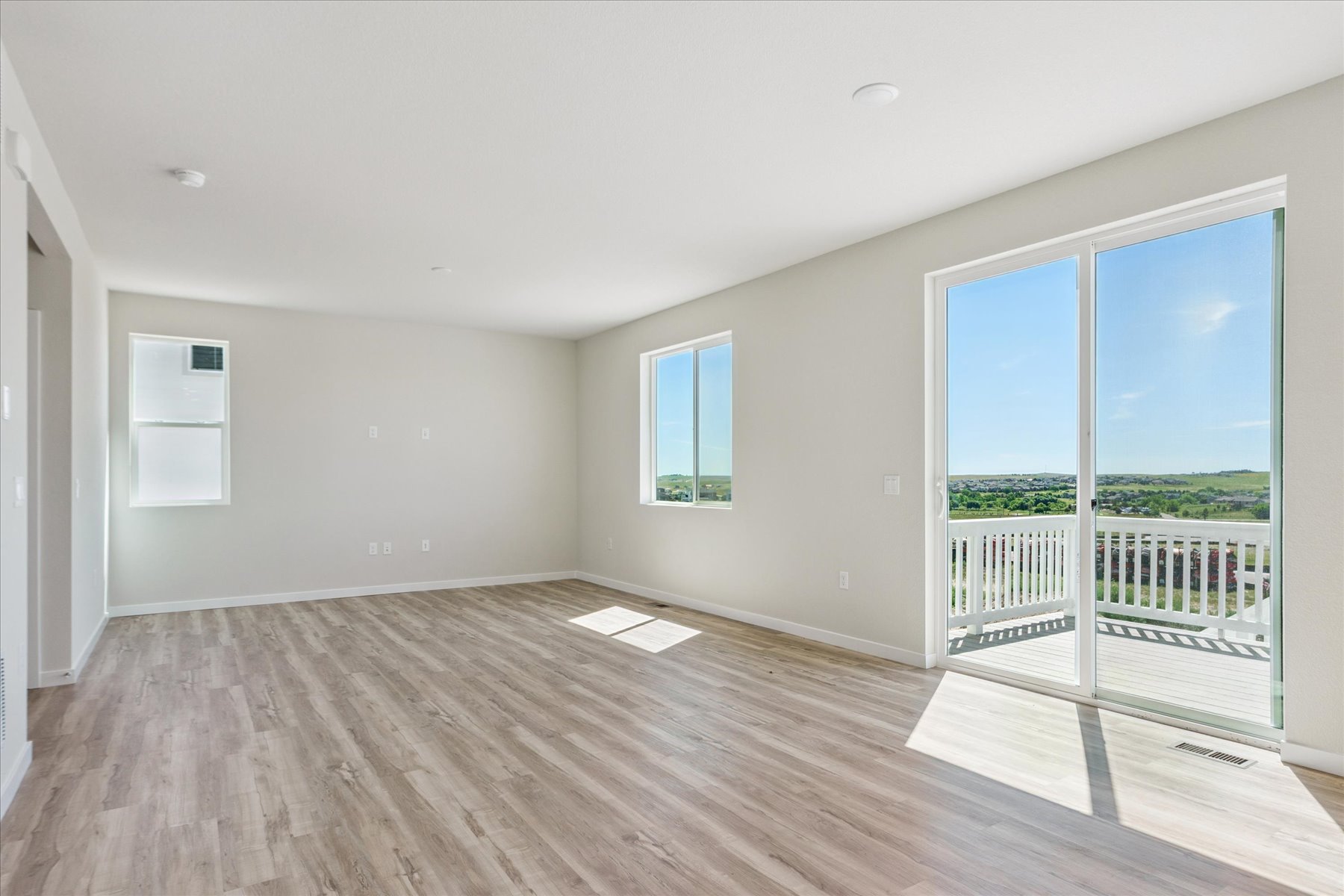 A room with a wood floor and windows.