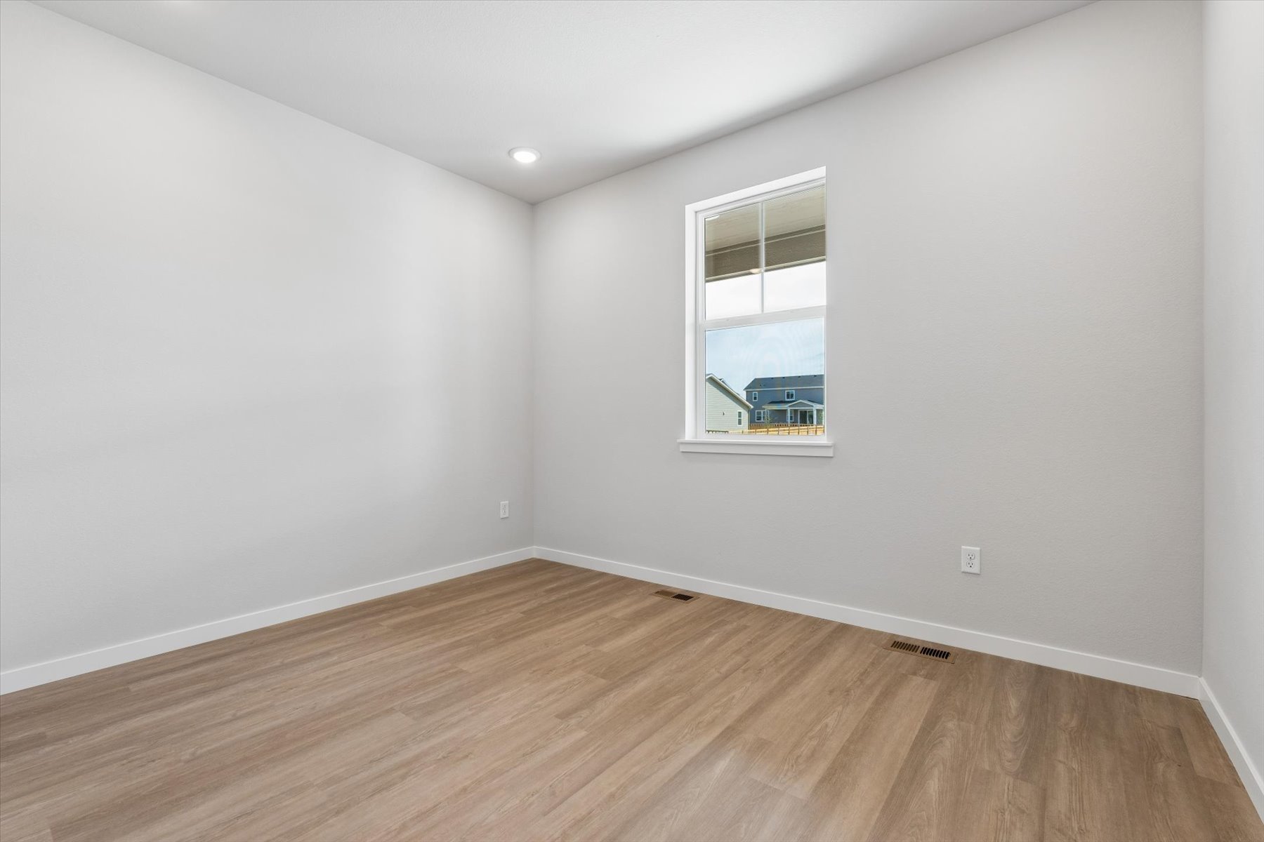 A room with a wood floor and a window.