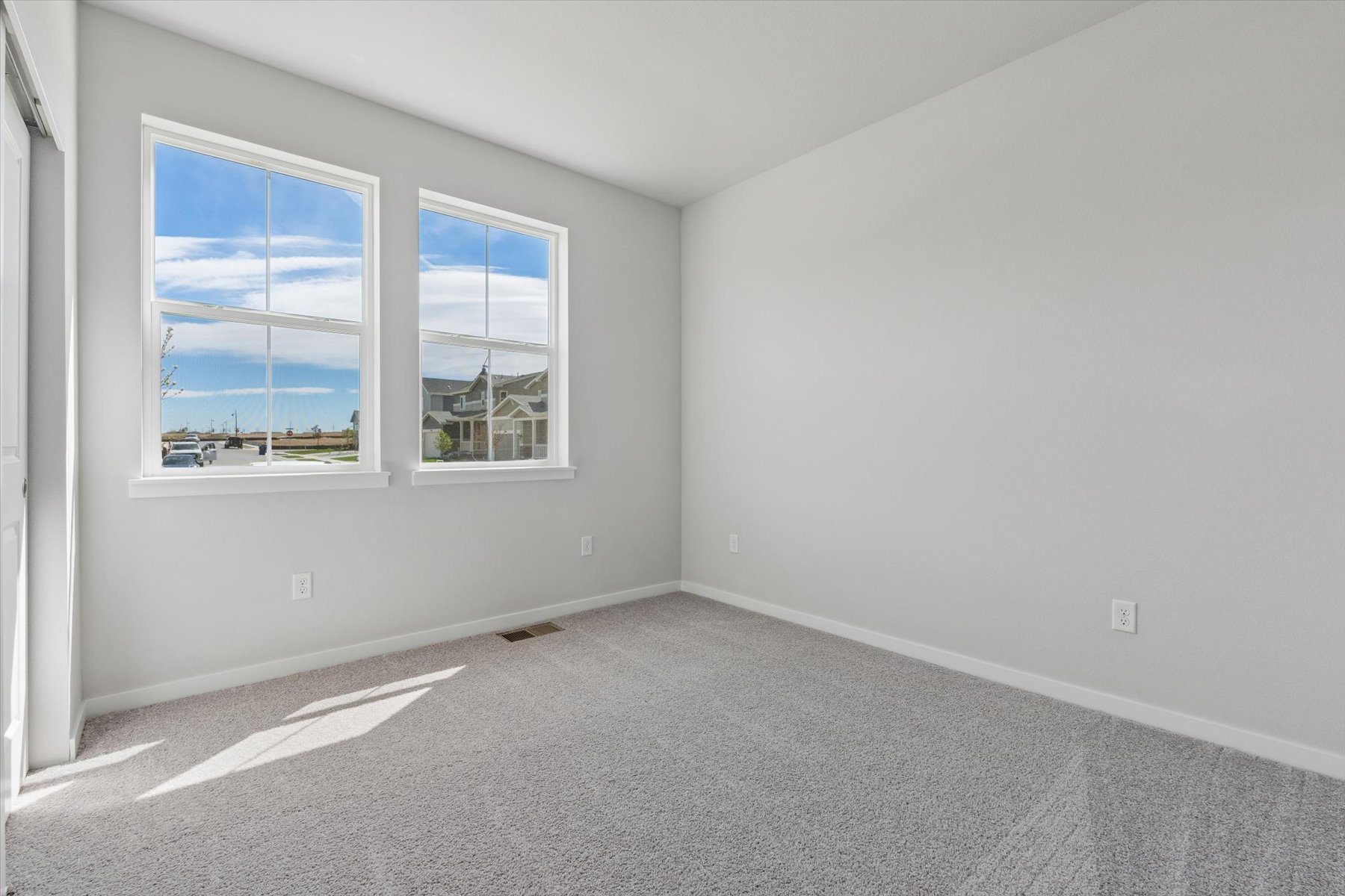 A room with a window and a carpet.