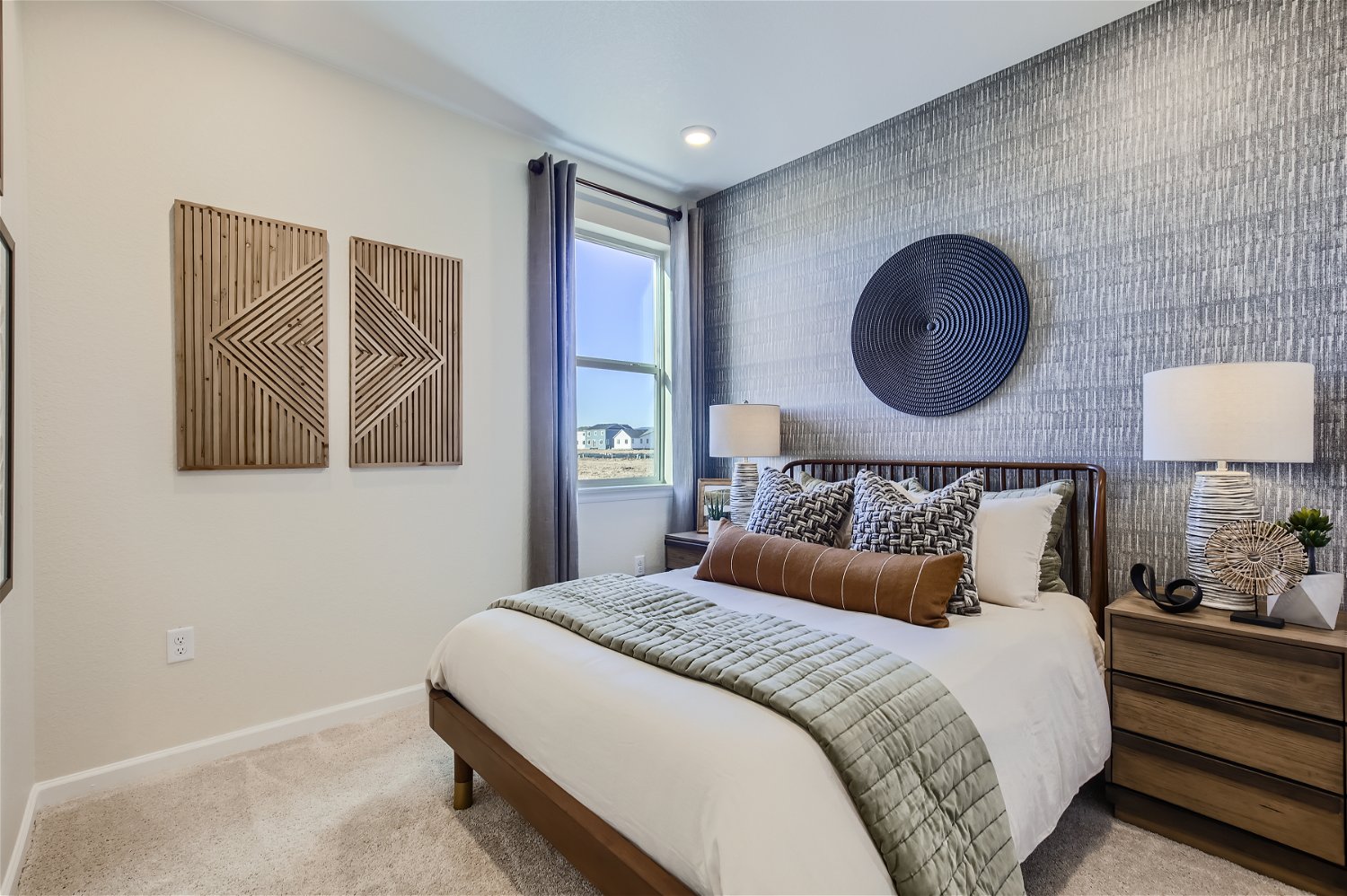 A bedroom with a bed and lamps.