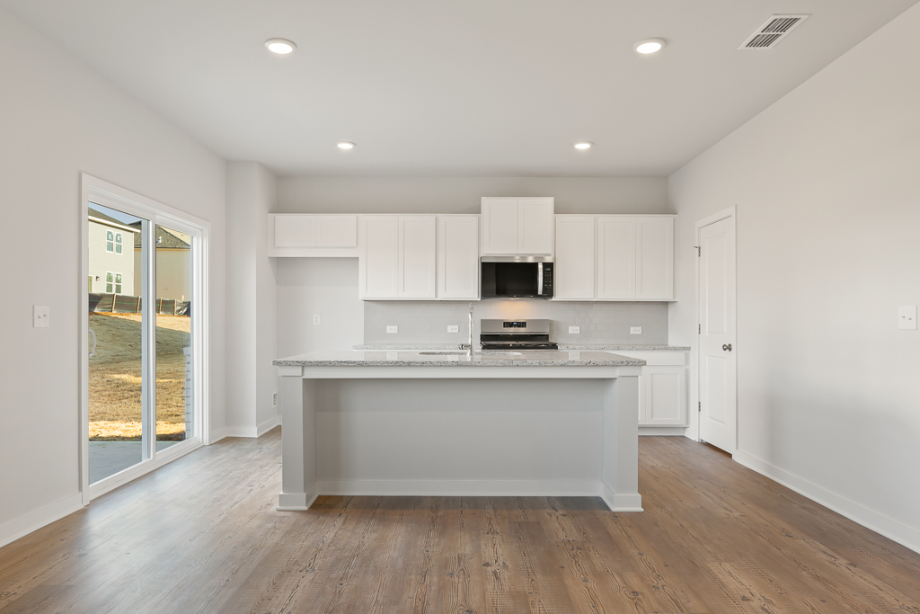 A kitchen with white cabinets.