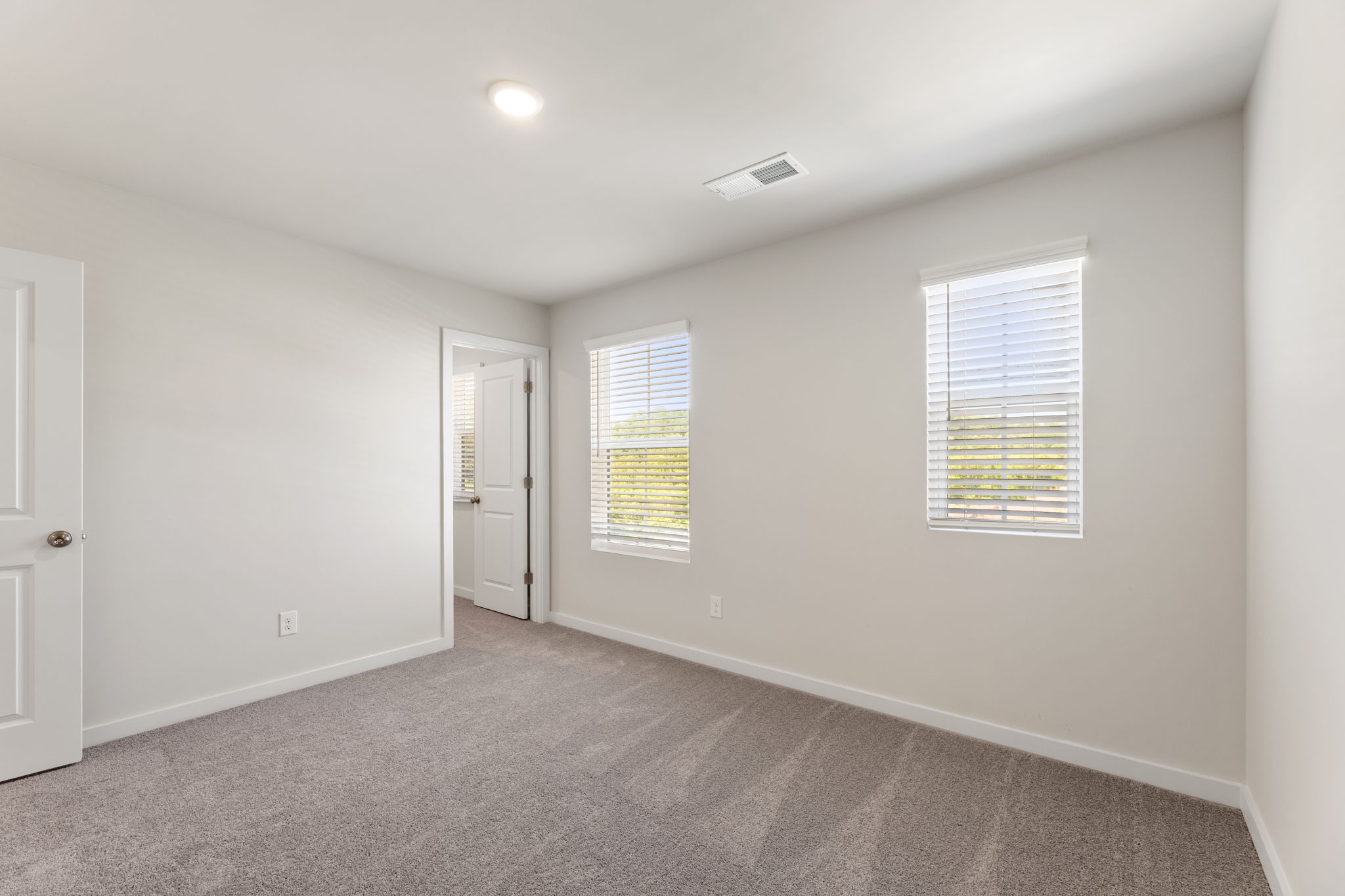 A room with a carpet and a door.