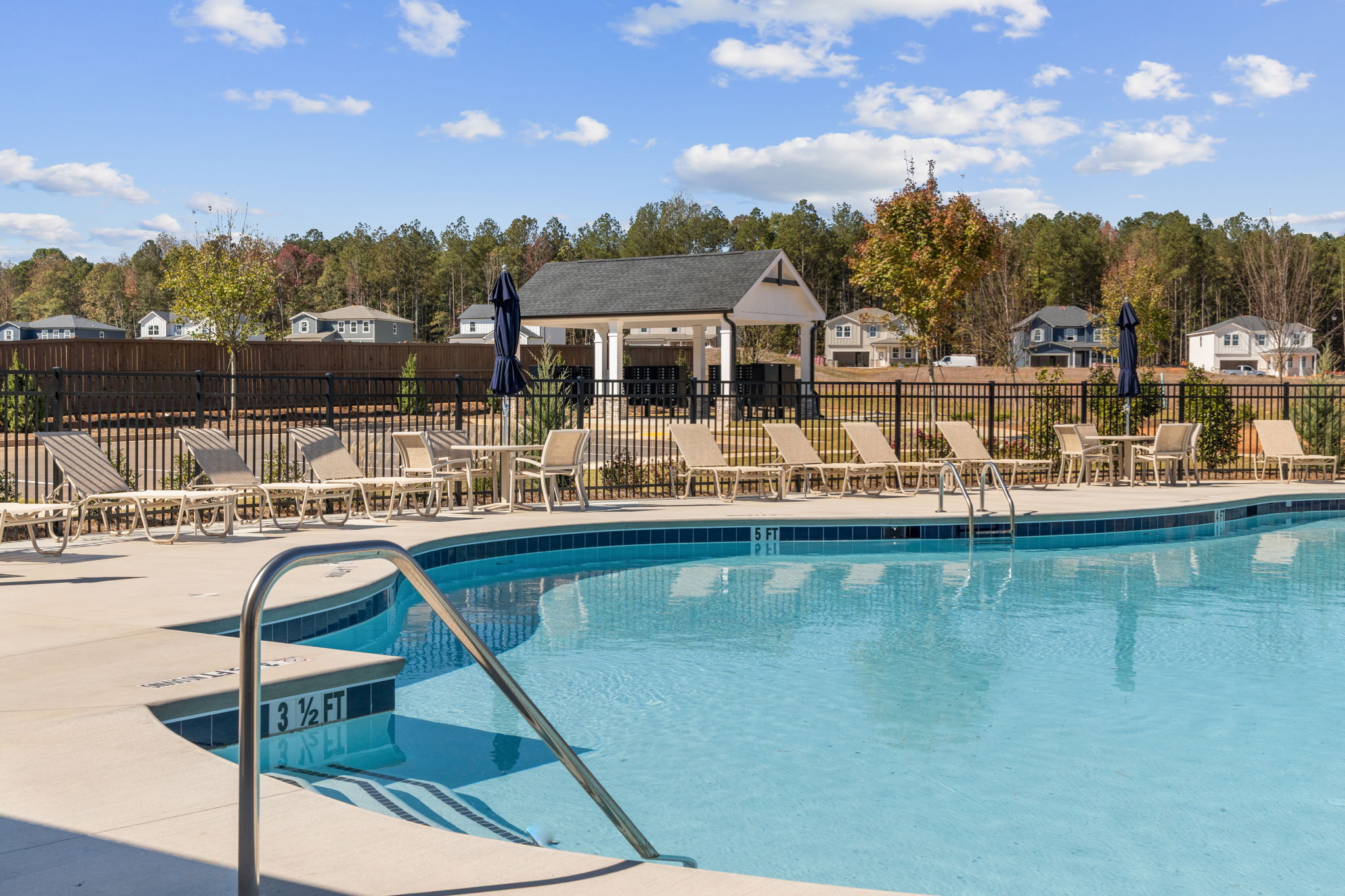 A pool with chairs around it.