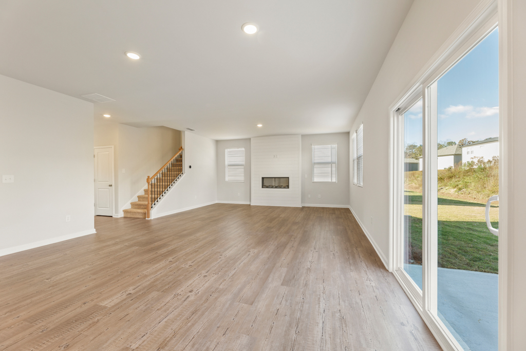 A large room with a wood floor and a large glass door.
