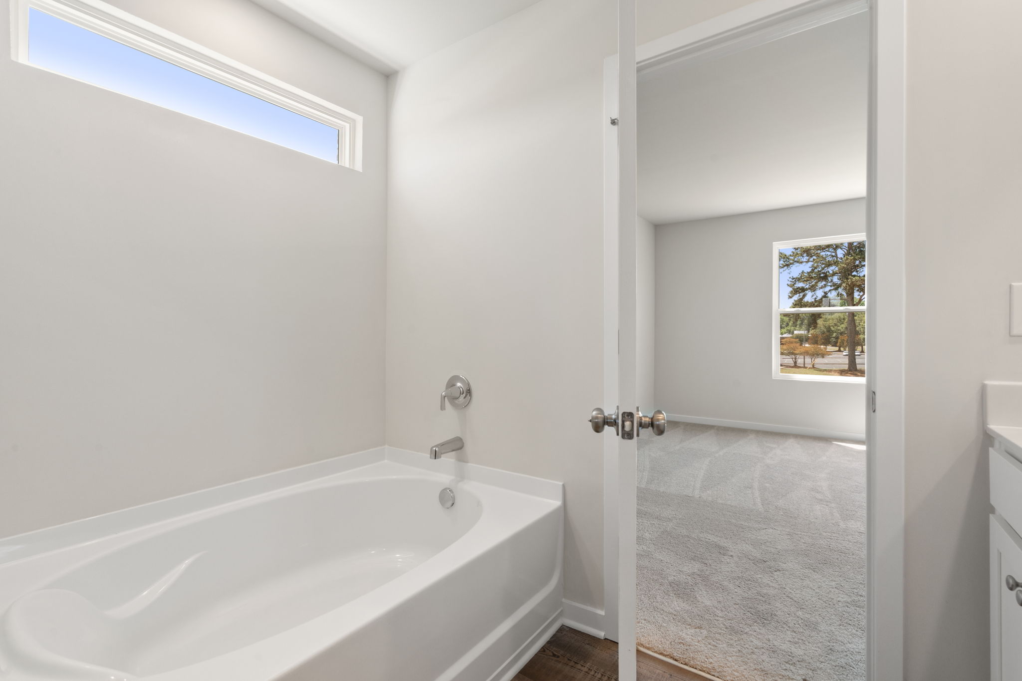 A bathroom with a tub and a window.