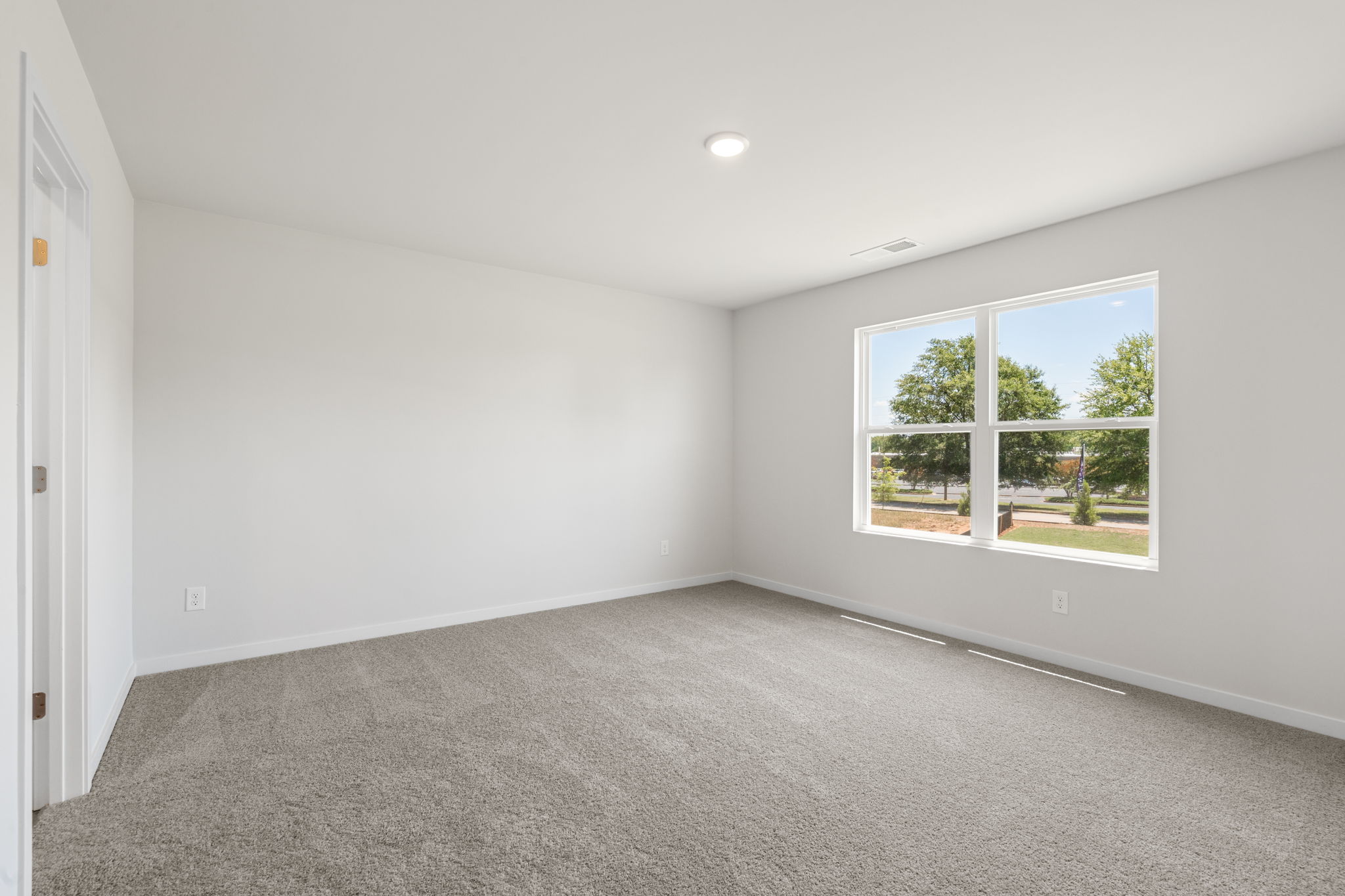 A room with a window and a carpet.