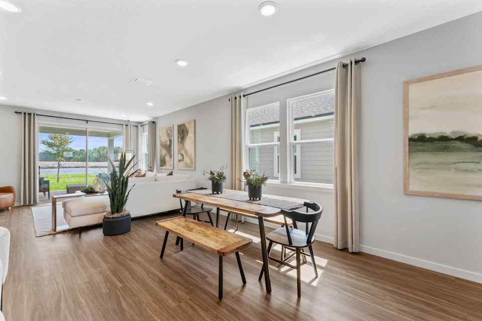 Silverbell II Model Home Dining Area with Table Next to Living Room at Camden Woods in Kingsland, GA