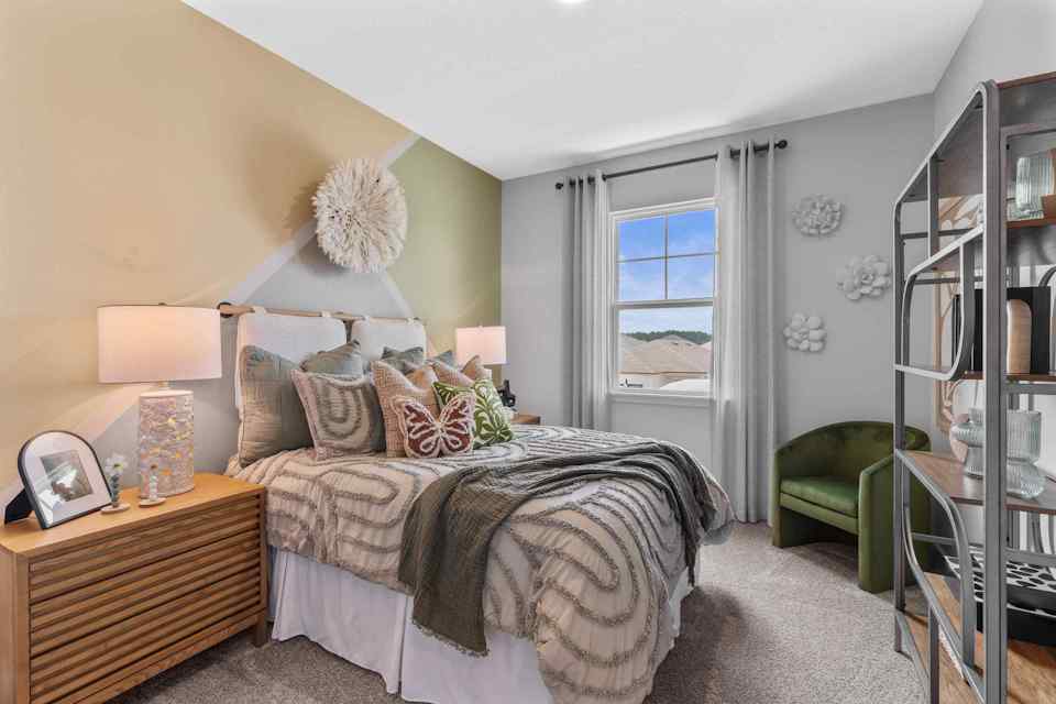 Silverbell II Model Home Guest Room with Bed and Open Shelving Unit at Camden Woods in Kingsland, GA