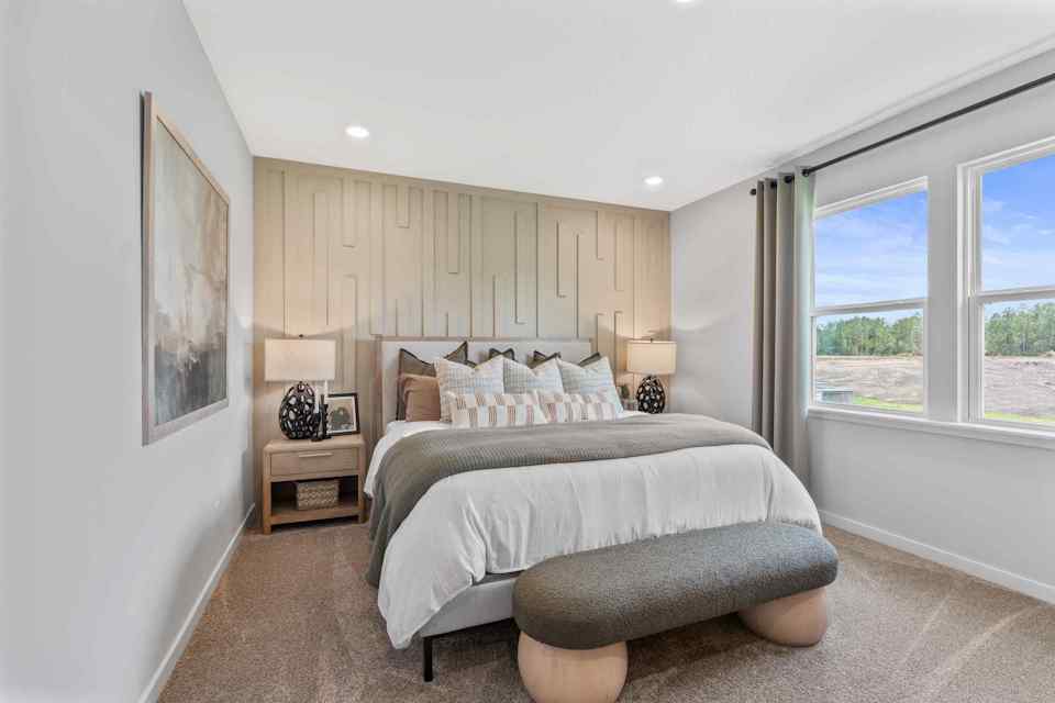 Silverbell II Model Home Primary Room with King Bed and End Couch at Camden Woods in Kingsland, GA.