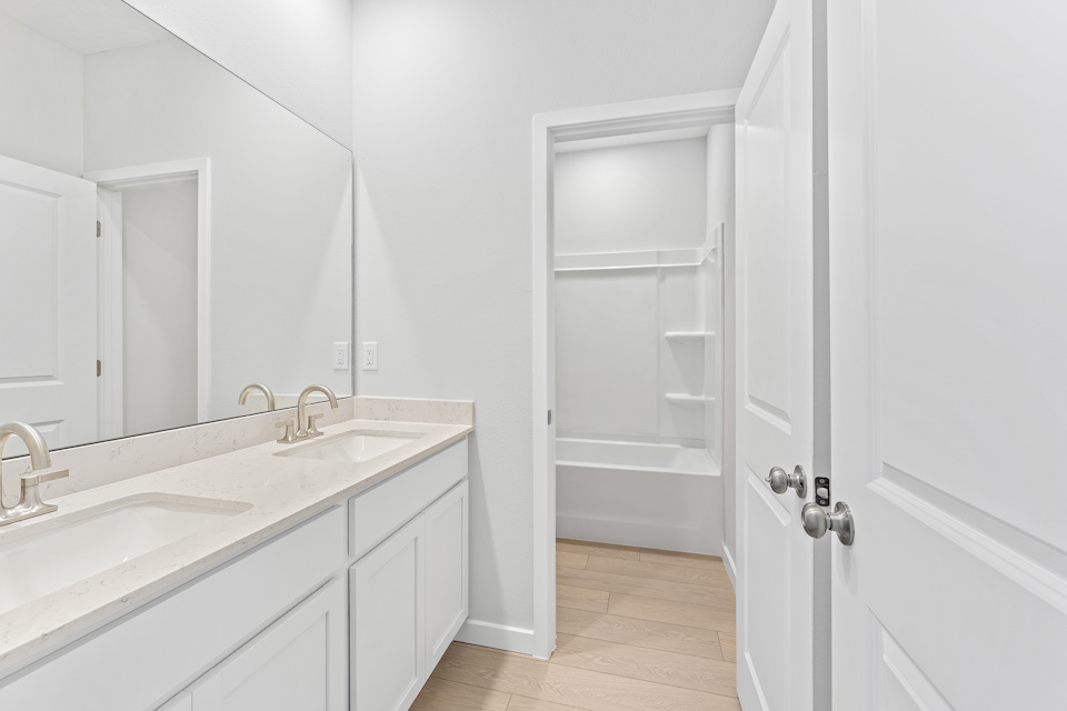Lot 20 Ponderosa II Guest Bathroom with Double Vanity Sink and Tub Shower Combo at Camden Woods in Kingsland, GA