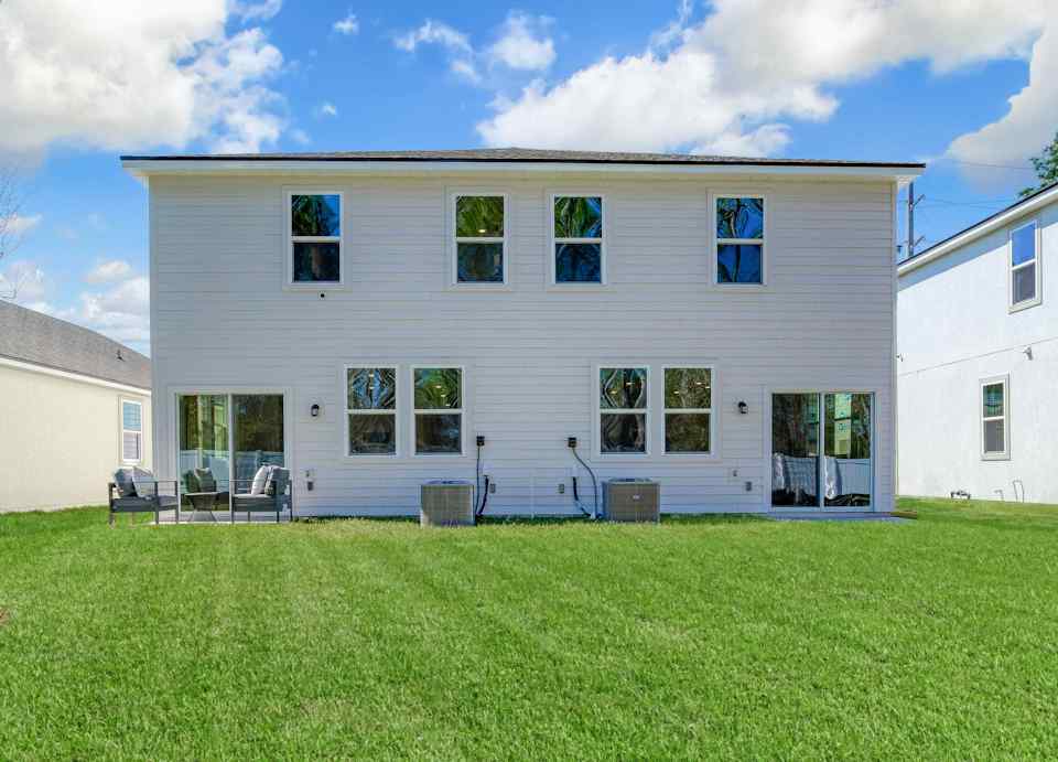 A white house with a green lawn.