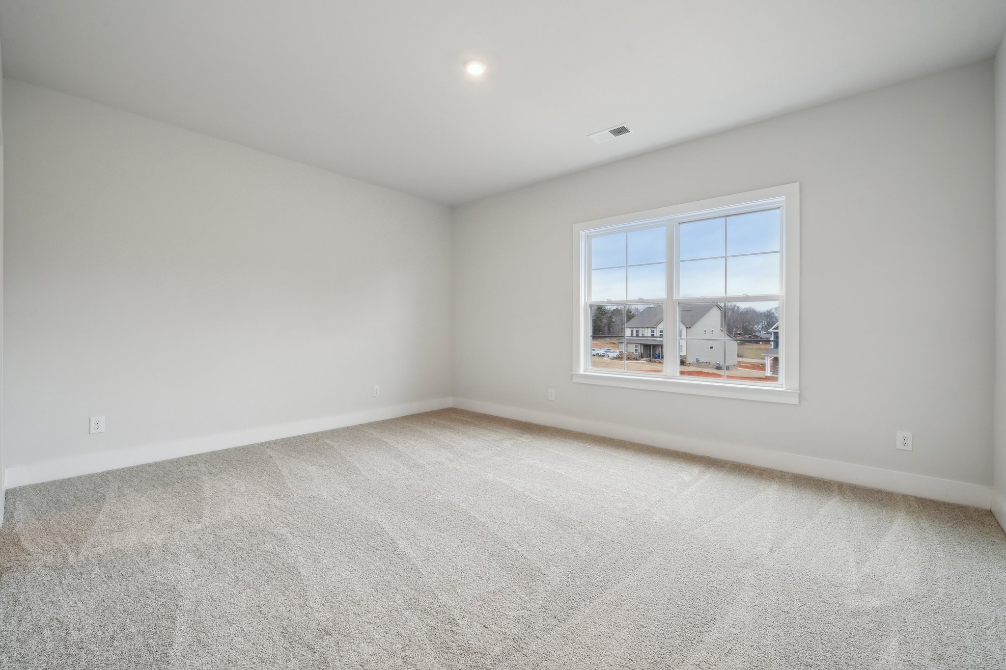 A room with a window and a carpet.