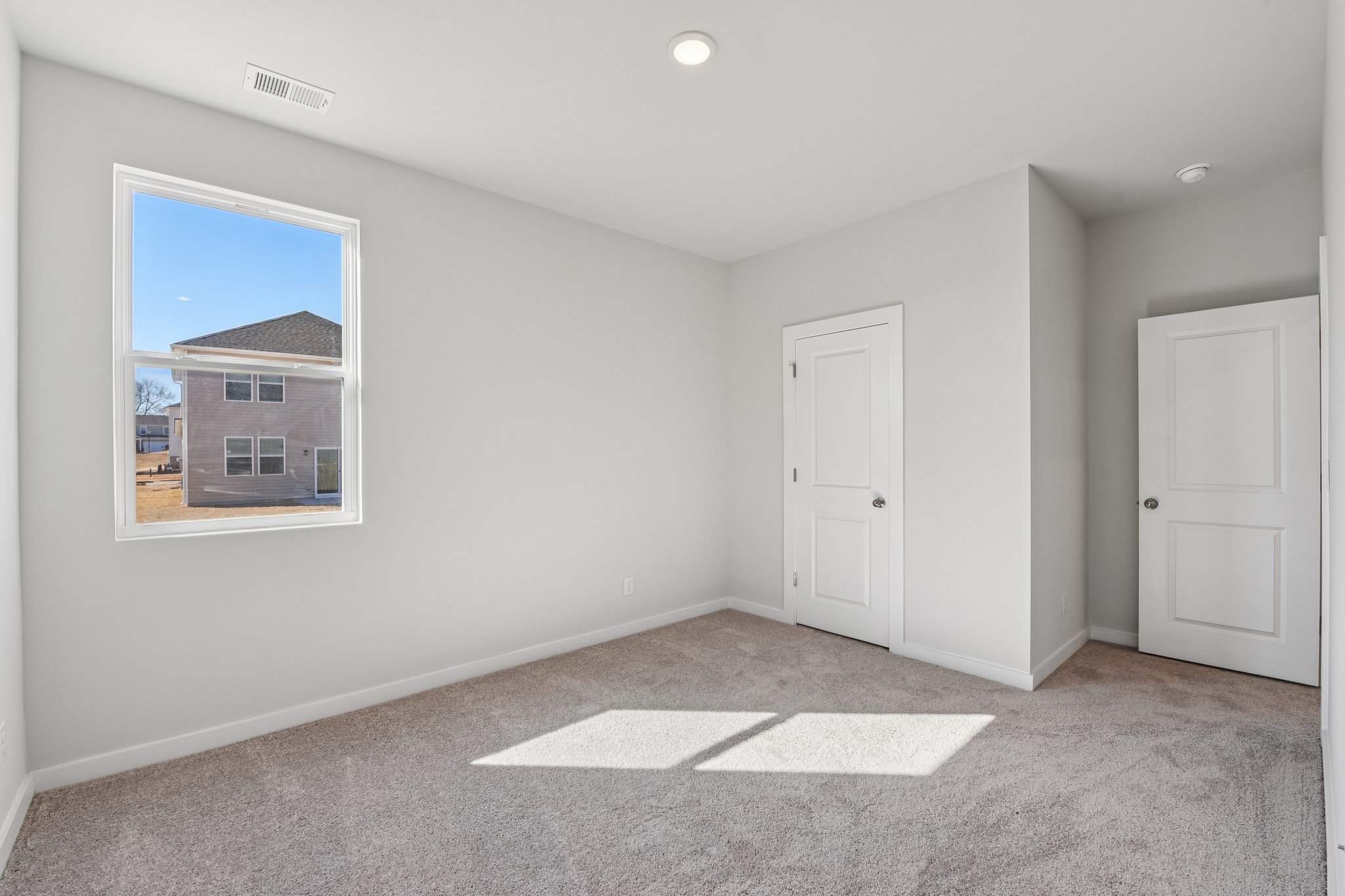 A room with white doors and a window.