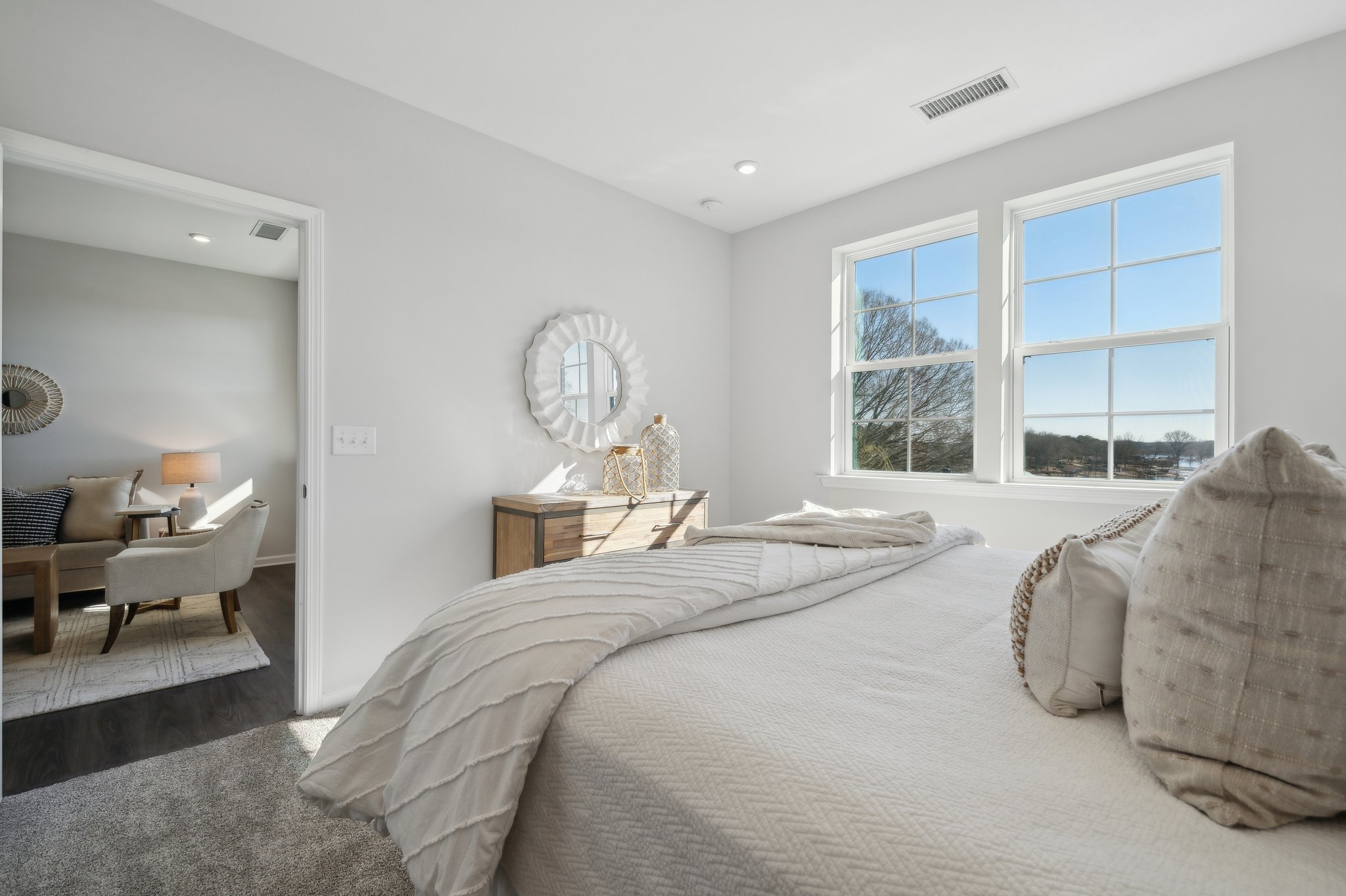 A bedroom with a bed and a mirror.