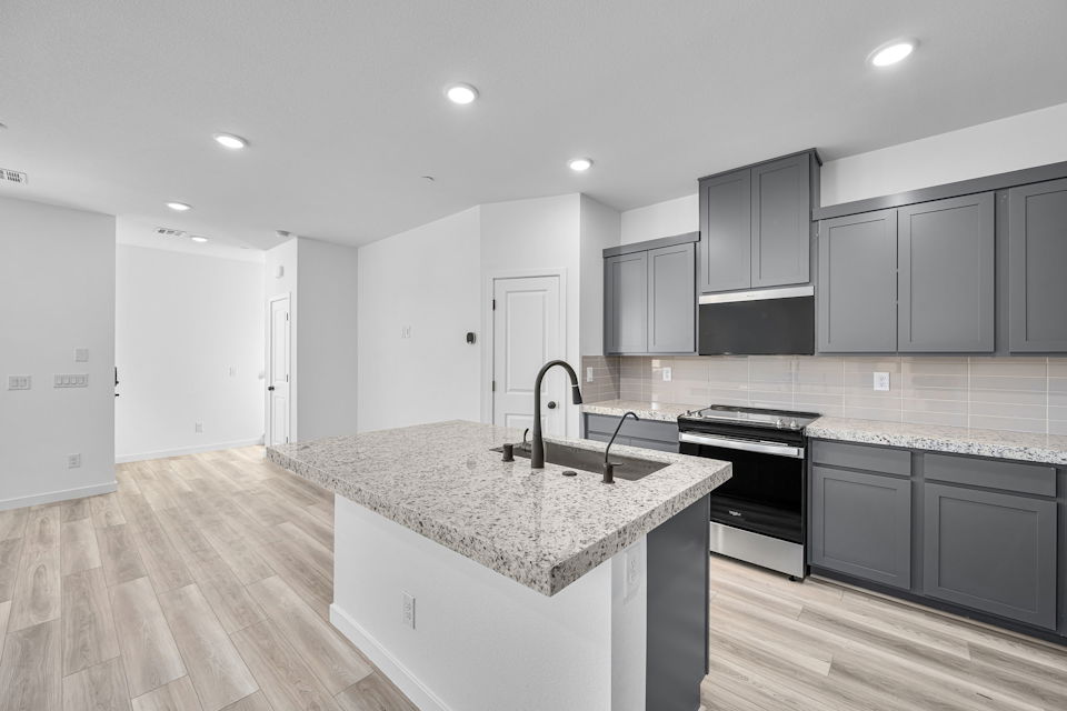 A kitchen with black cabinets.