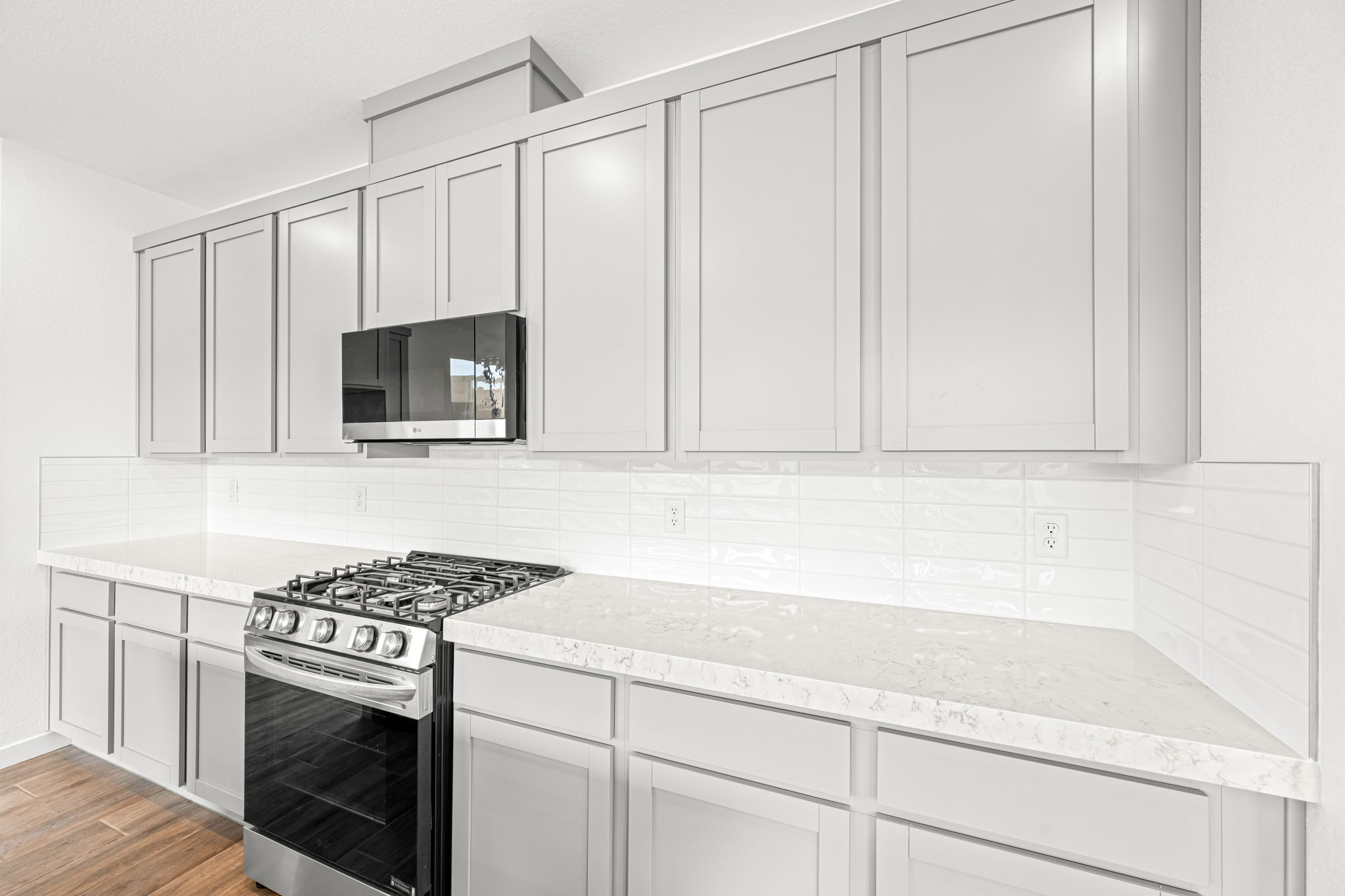 A kitchen with white cabinets.
