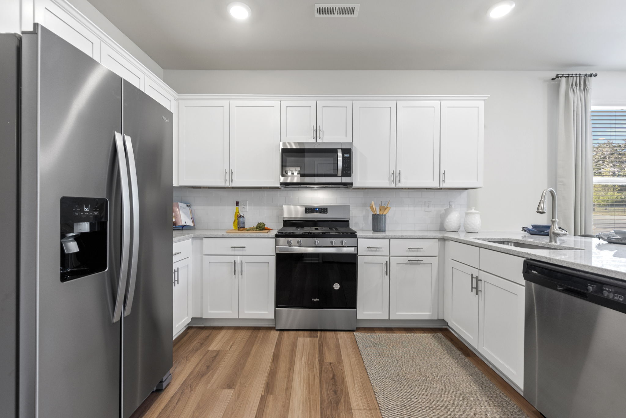 A kitchen with white cabinets.
