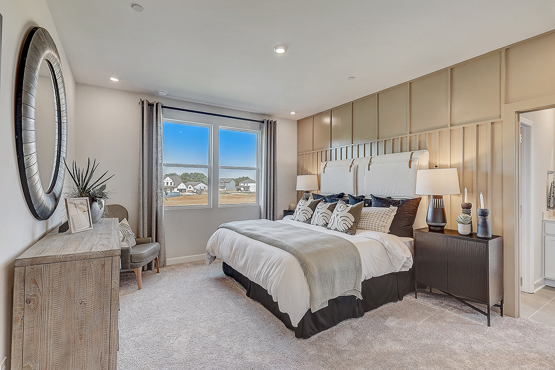 A bedroom with a large window.