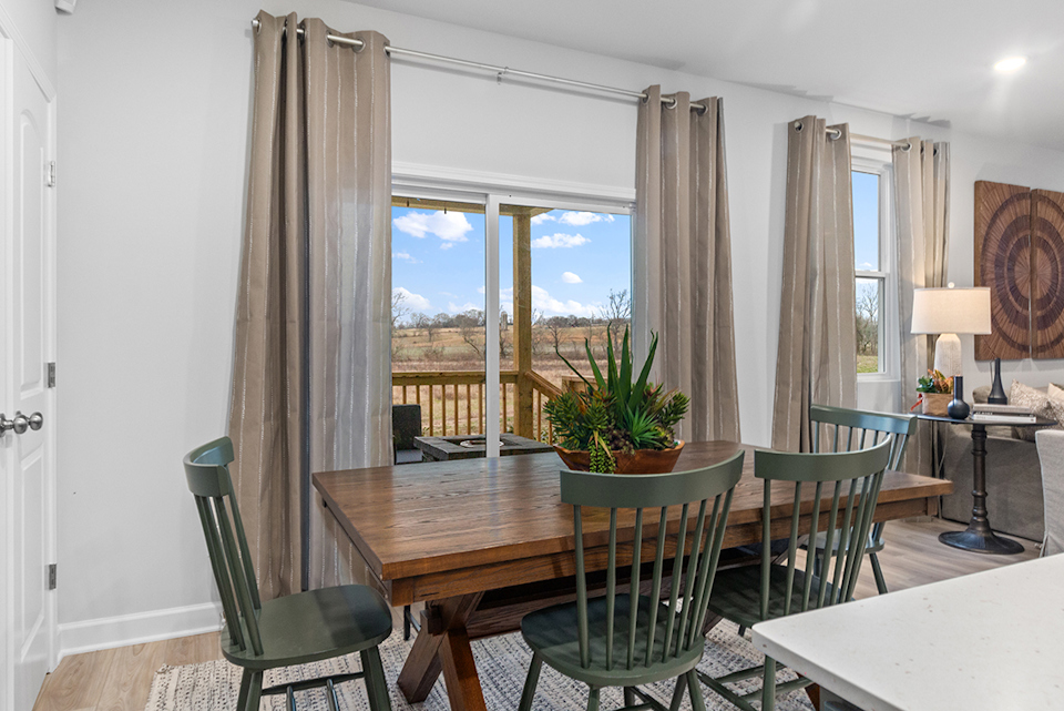 A dining room table with chairs and a view of the city.