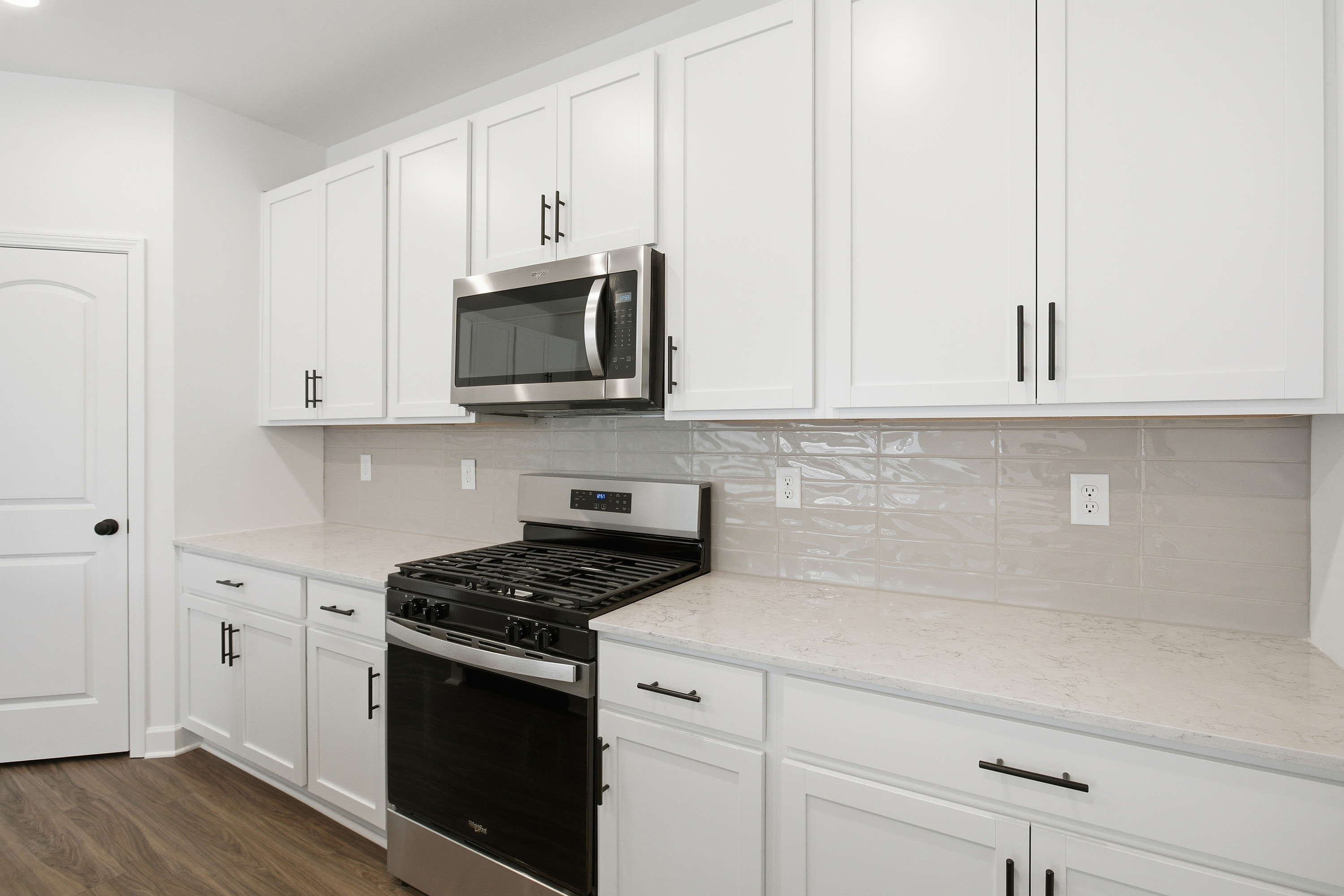 A kitchen with white cabinets.