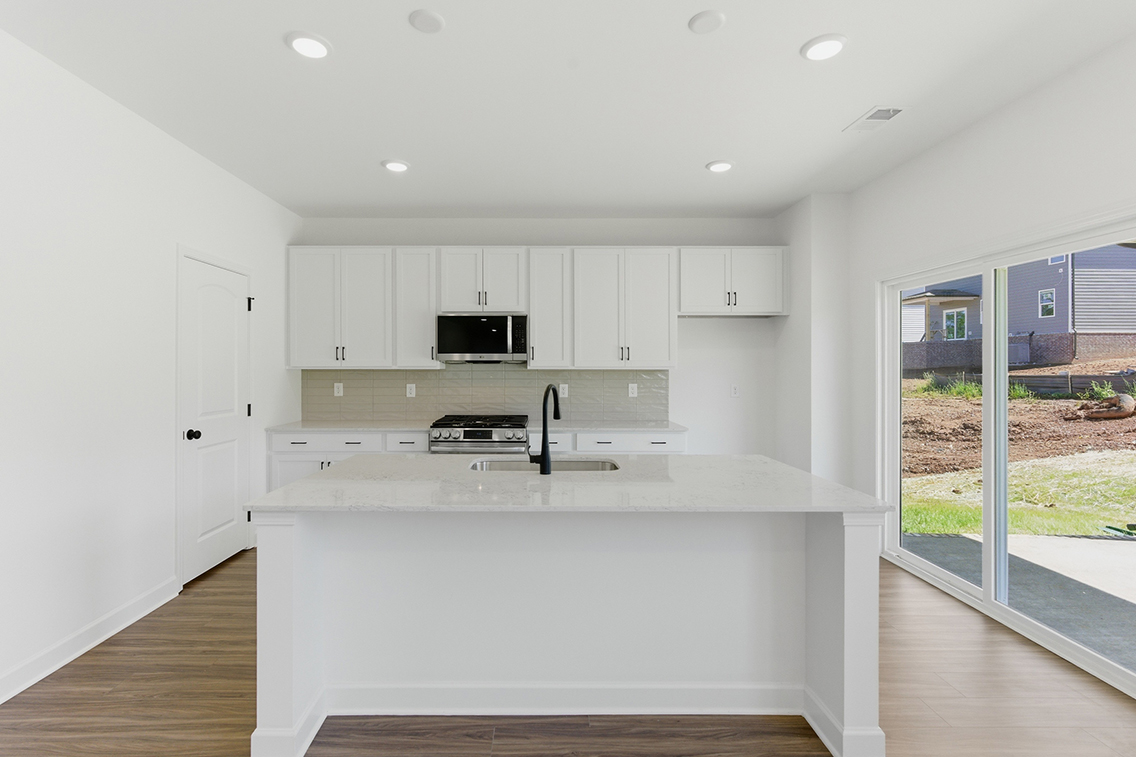 A kitchen with white cabinets.